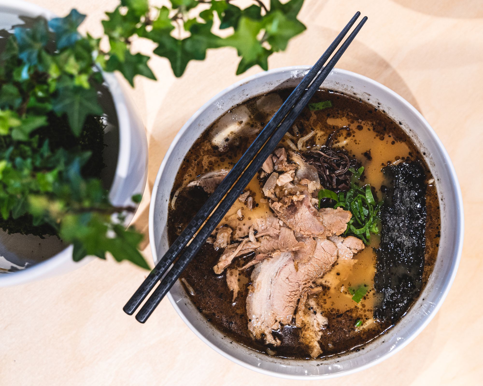 Overhead shot of a ramen bowl with chopsticks resting on-top