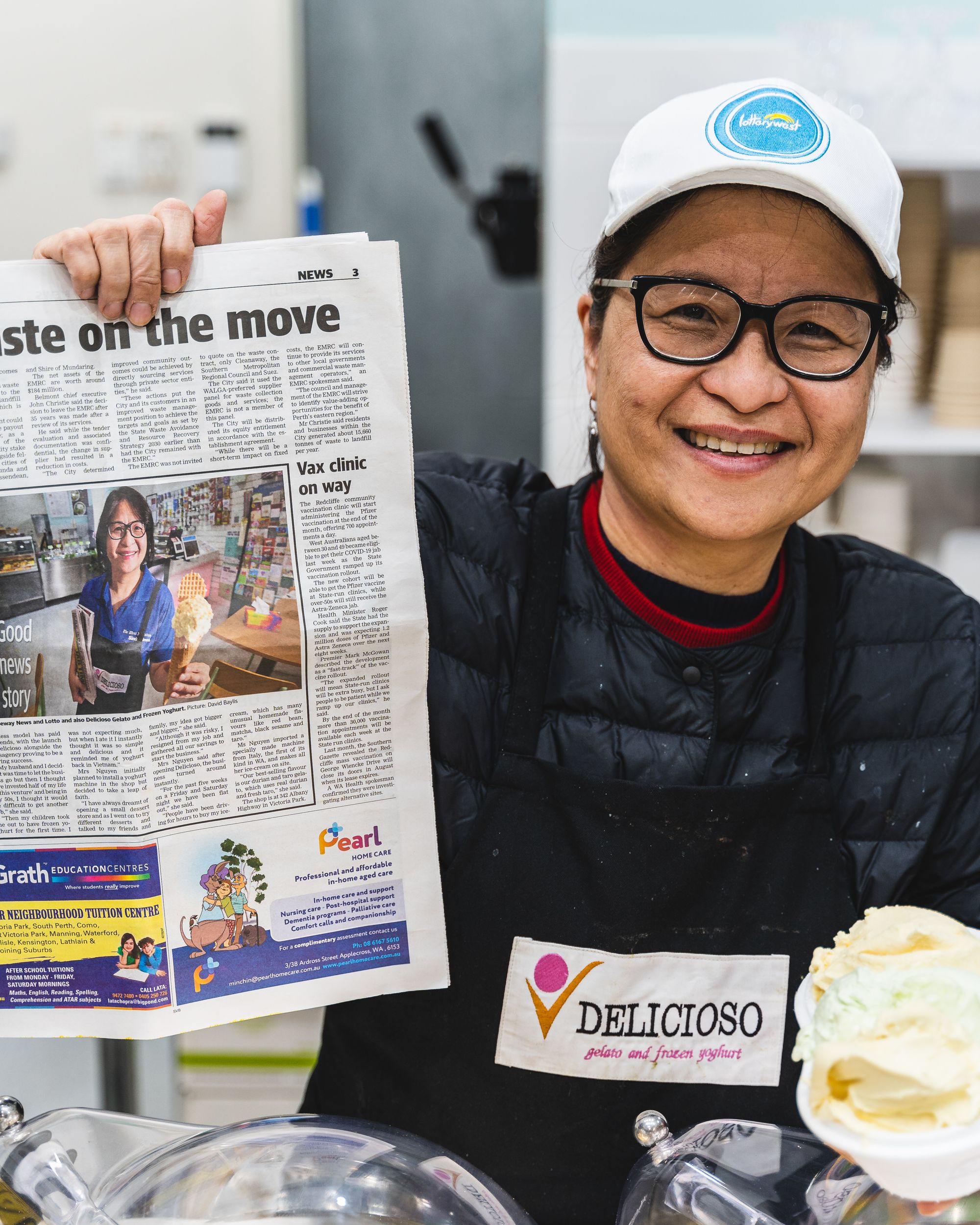 Woman smiling while holding a newspaper article with her in it