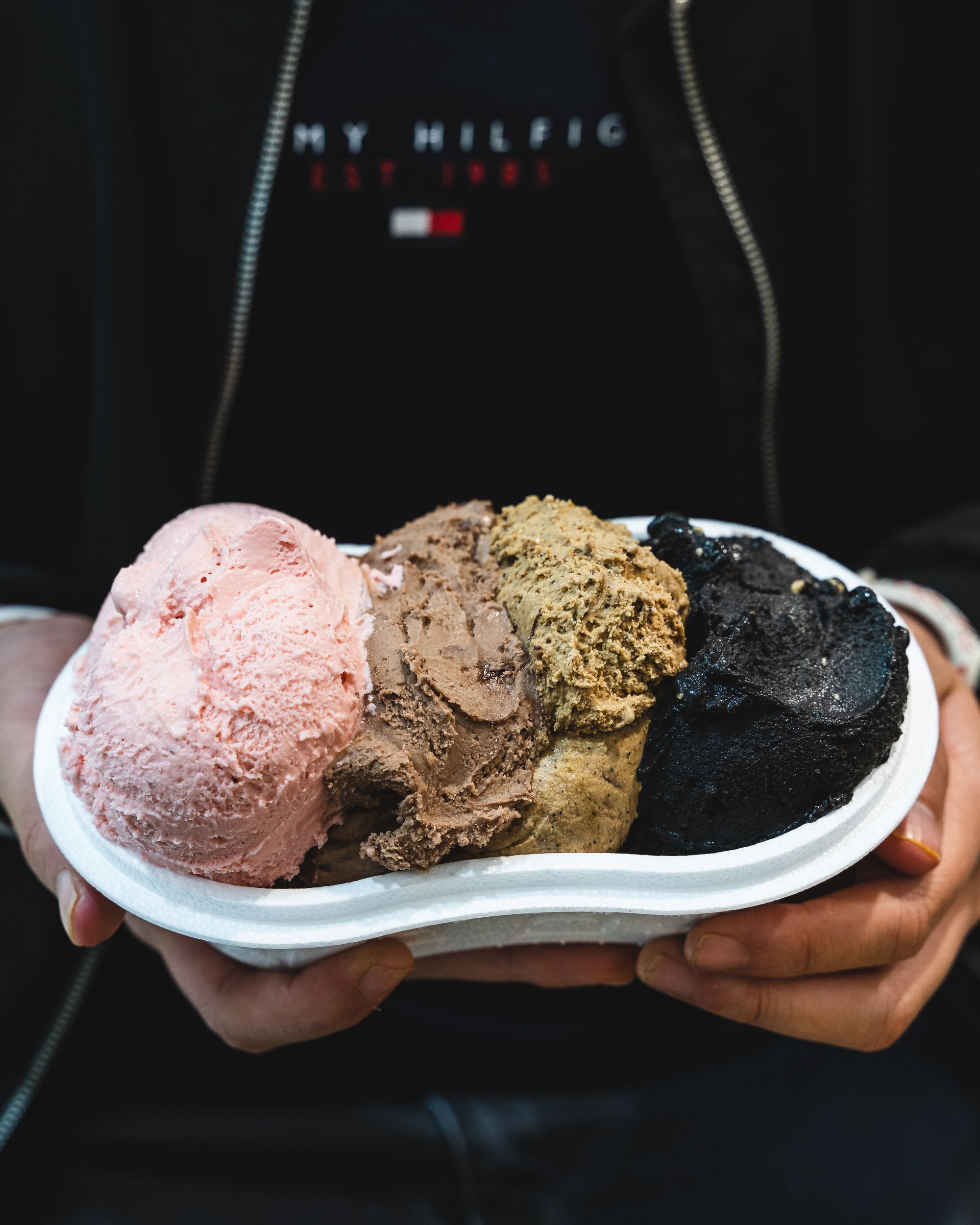 A hand holding a tub of ice-cream