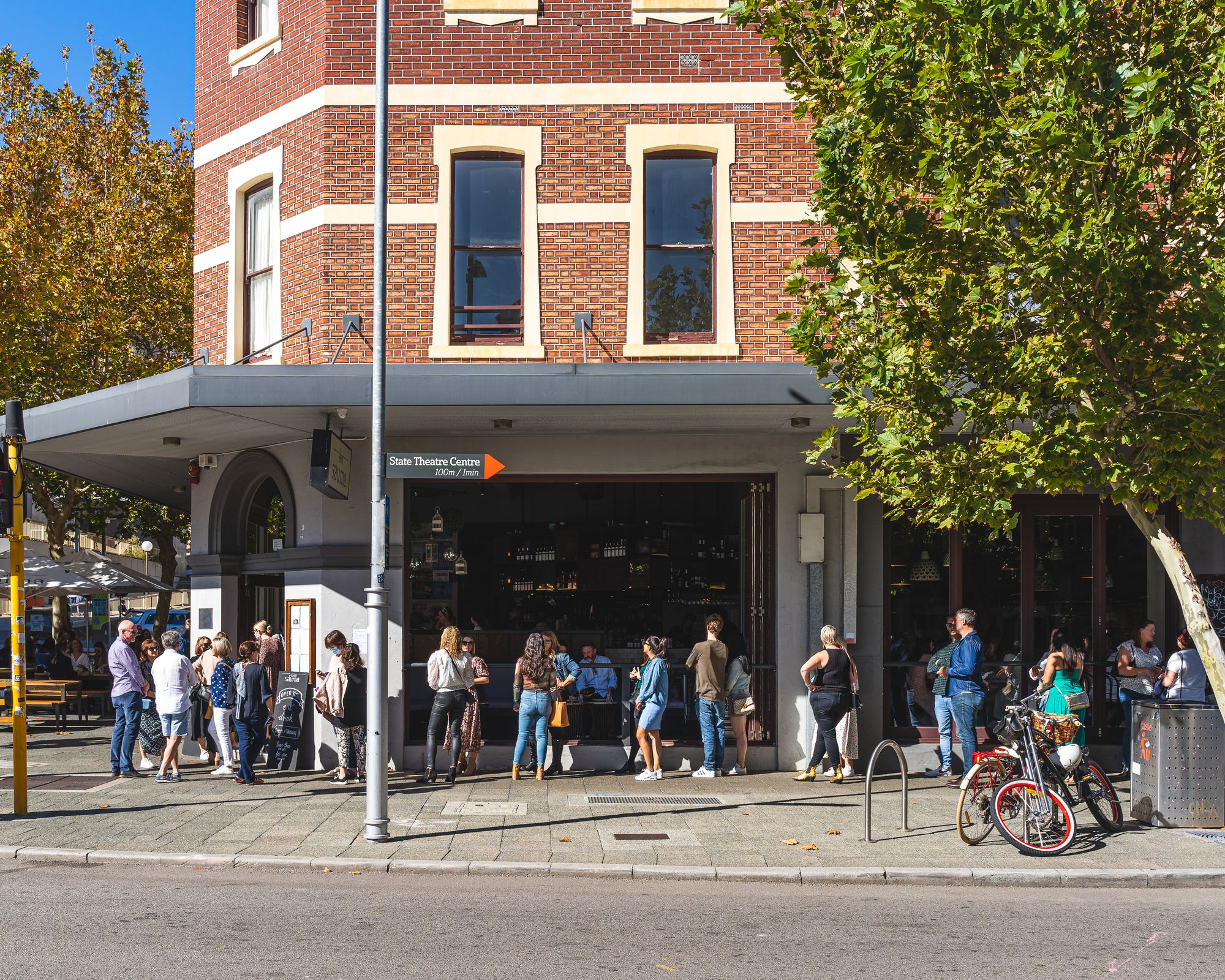 Daytime shot of people lining up to go inside a restaurant