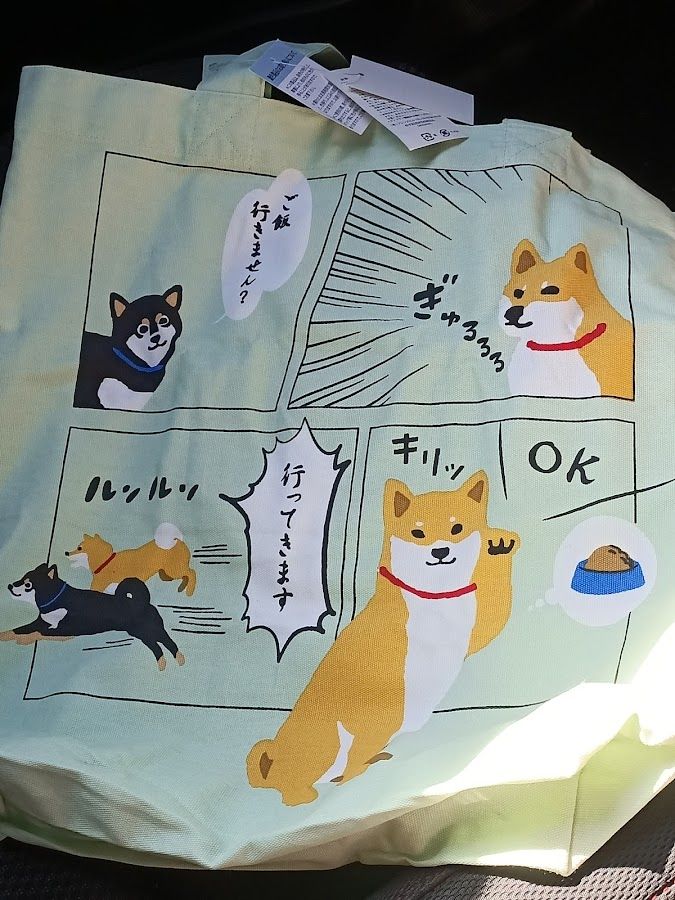 A green tote bag with a Shiba inu manga on it