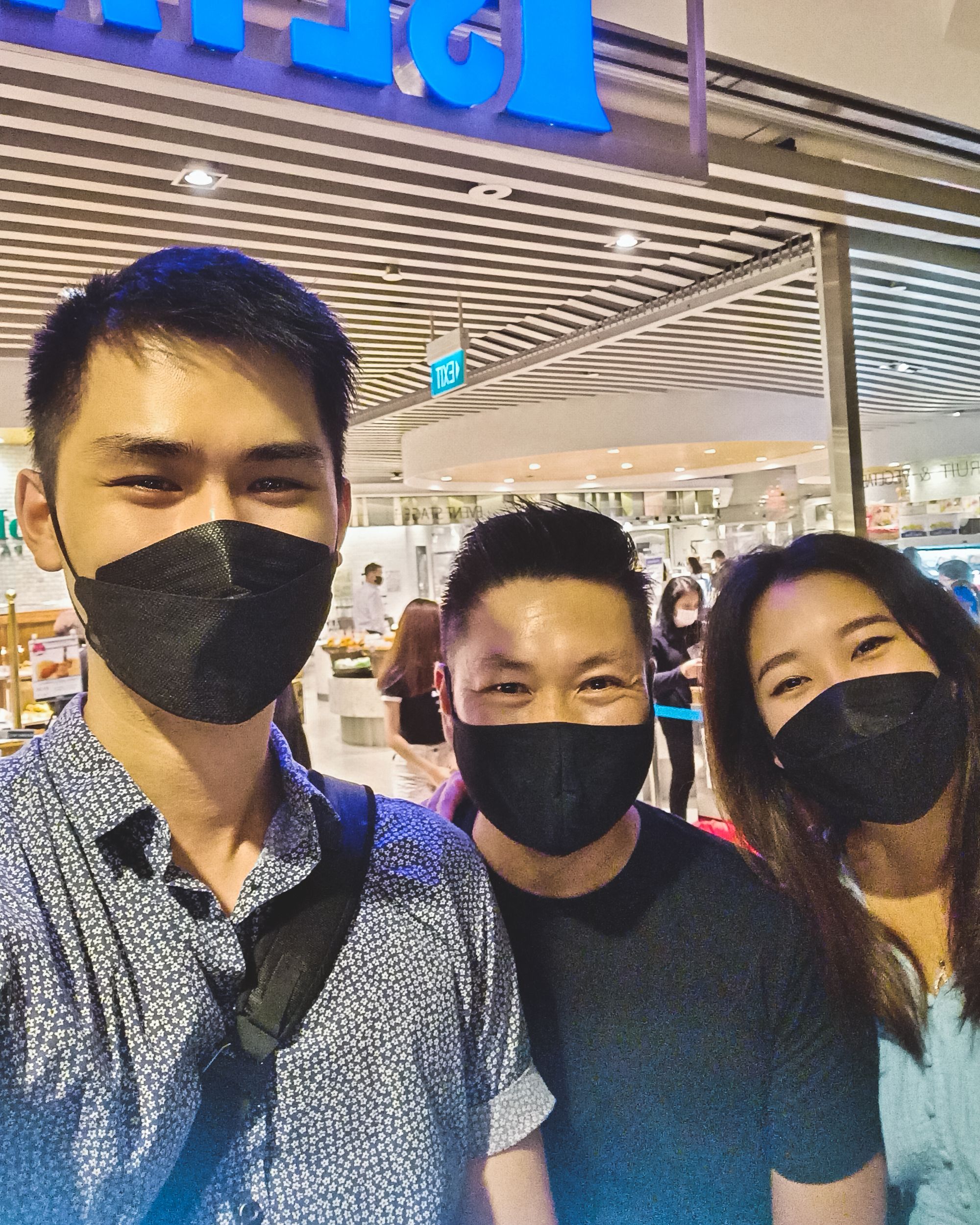 Selfie of two Asian men and an Asian woman, all wearing black face masks