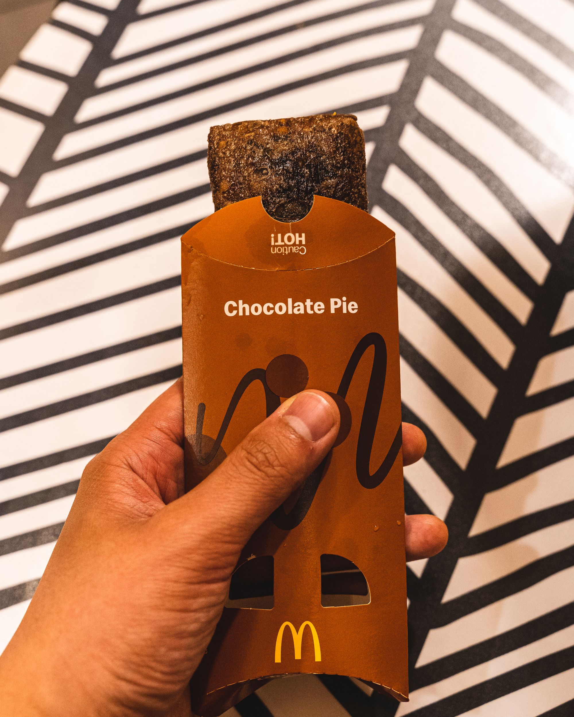 Close up of hand holding McDonalds' chocolate pie