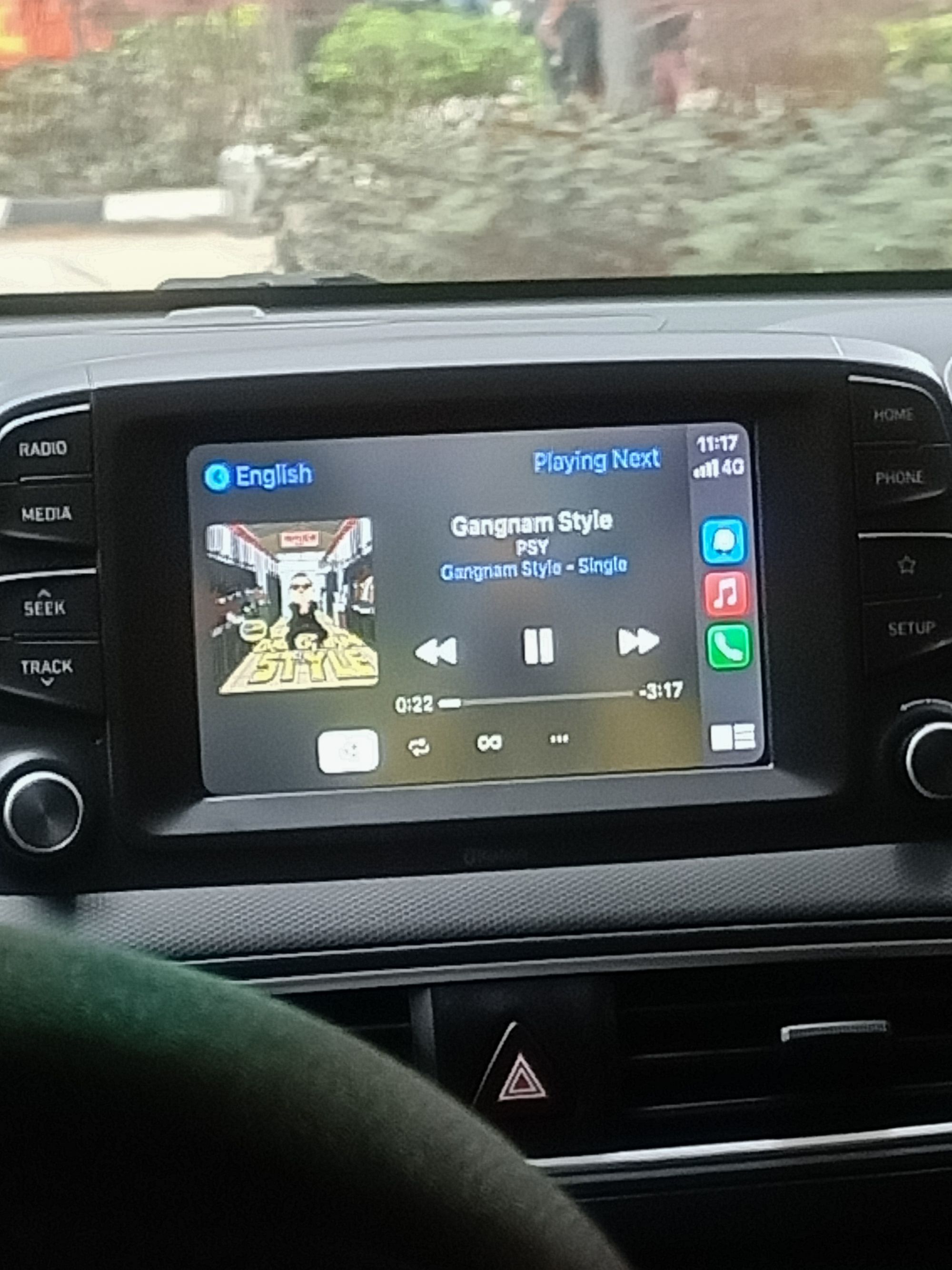 A photo of a screen in a car showing "PSY's Gangnam Style playing"