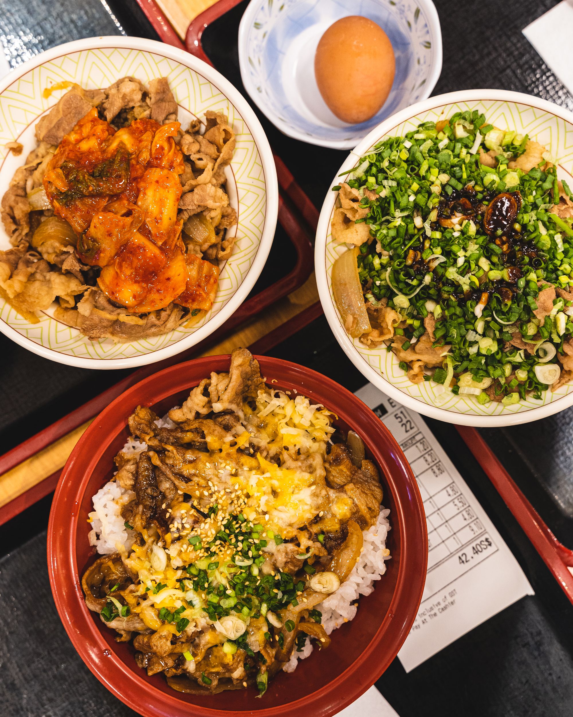 Three bowls of rice bowls with different toppings (pork and kimchi, beef and pork and beef and negi)