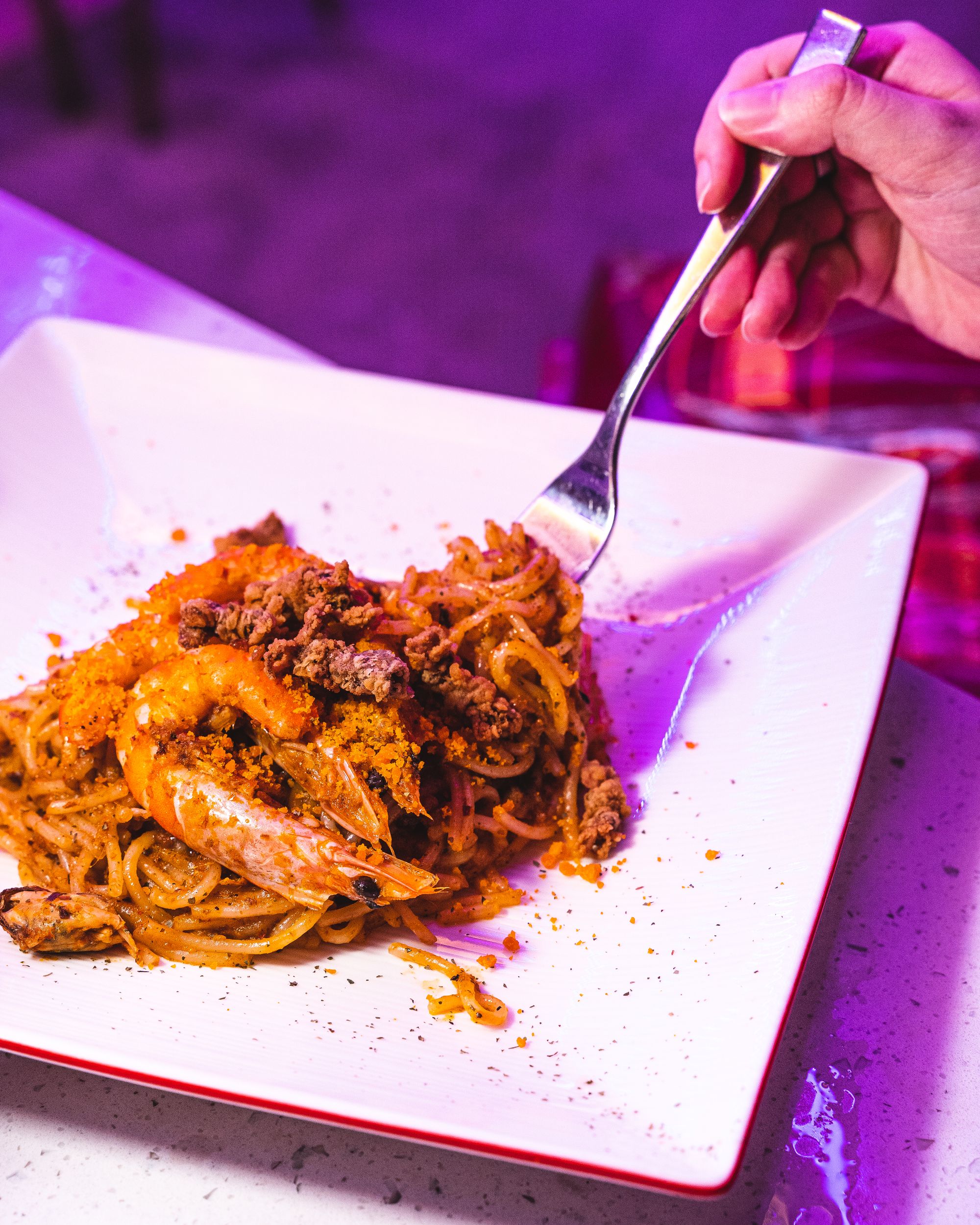 A plate with noodles on it with a prawn showing