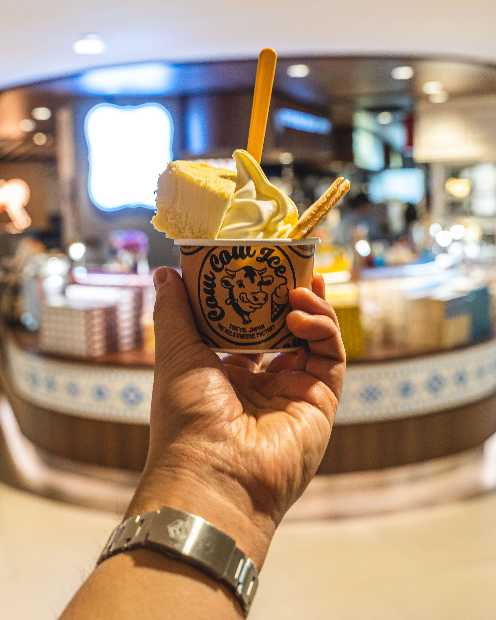 Close up shot of a hand holding a sundae in a cone