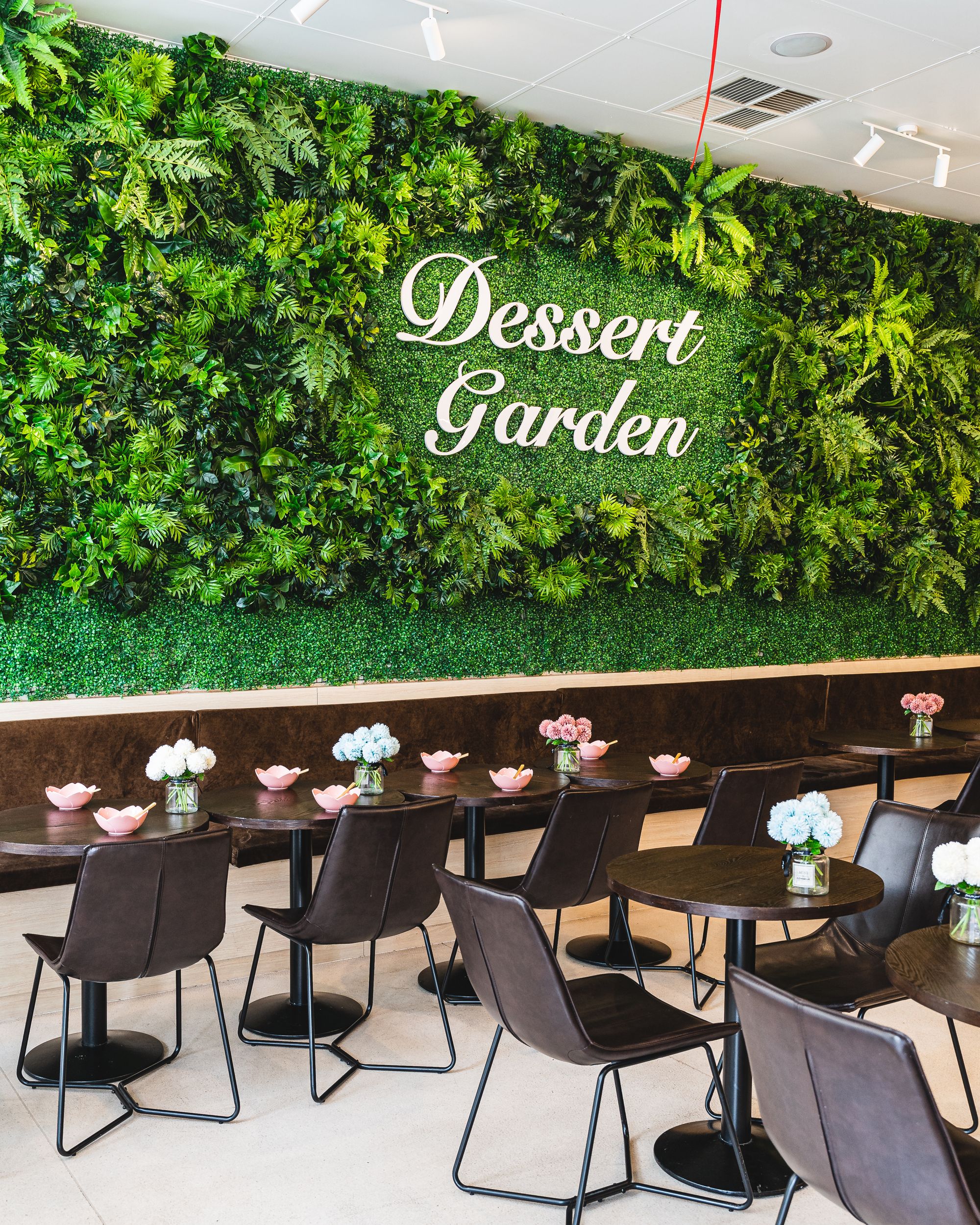 A restaurant interior with lots of chairs and tables with the sign "Dessert Garden" on the wall