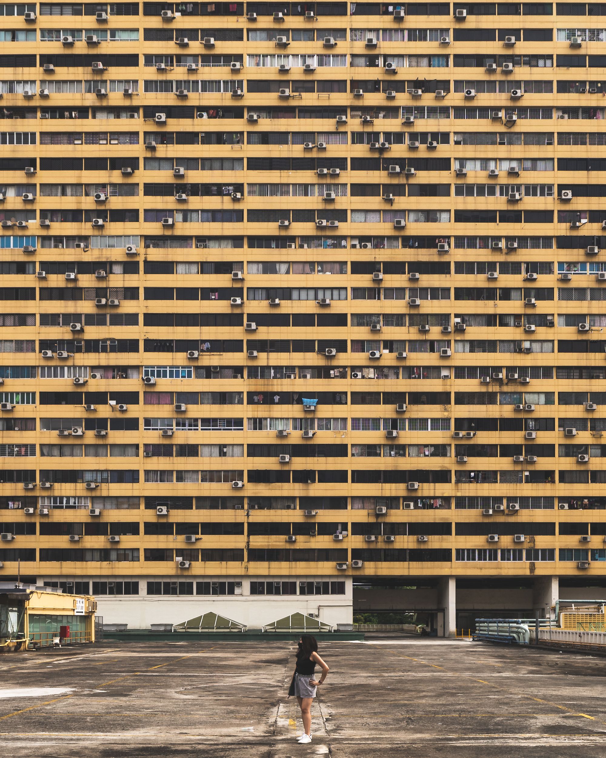 Girl standing in front of apartment building for scale