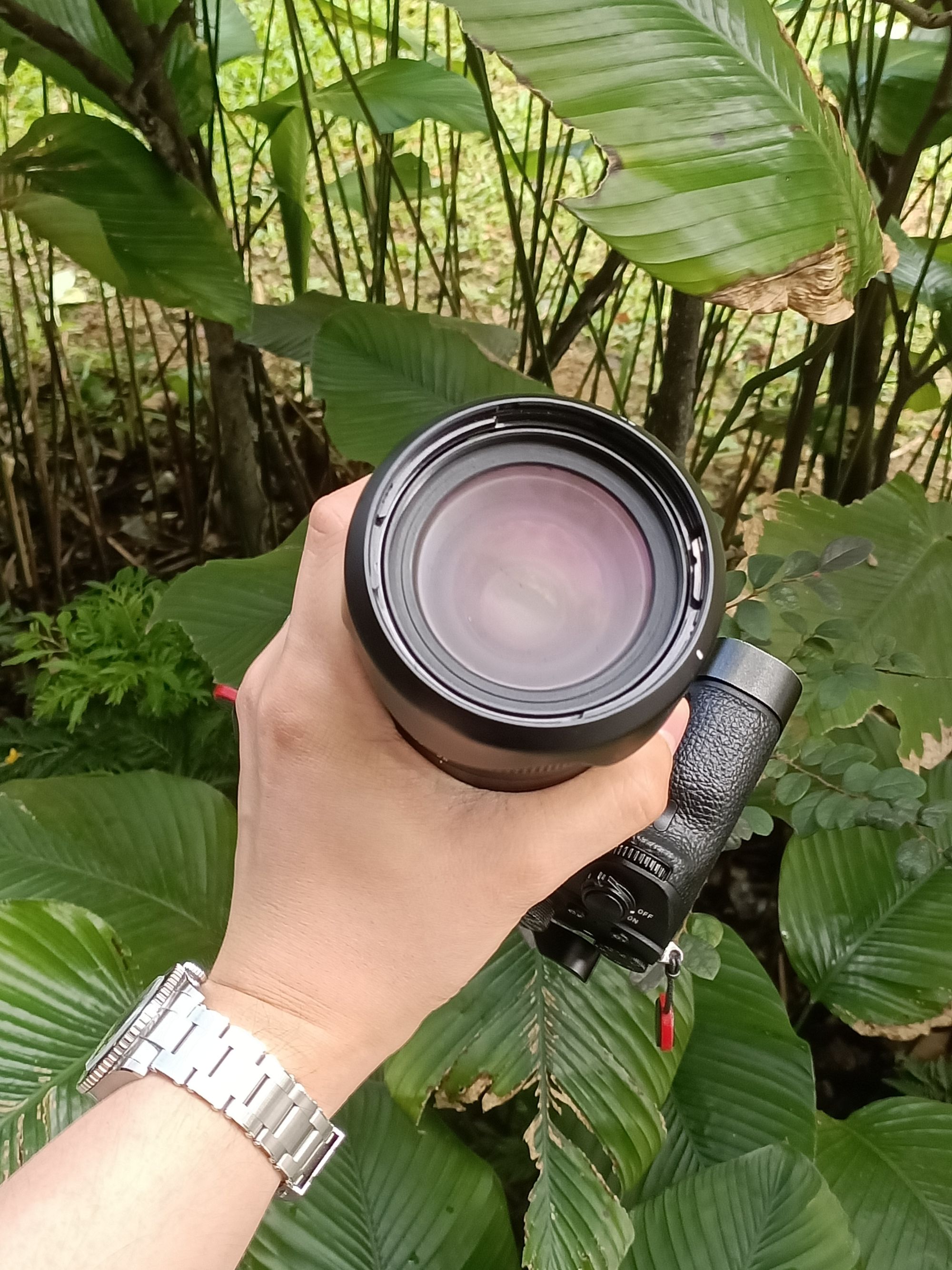 A hand holding a camera with its lens all fogged up