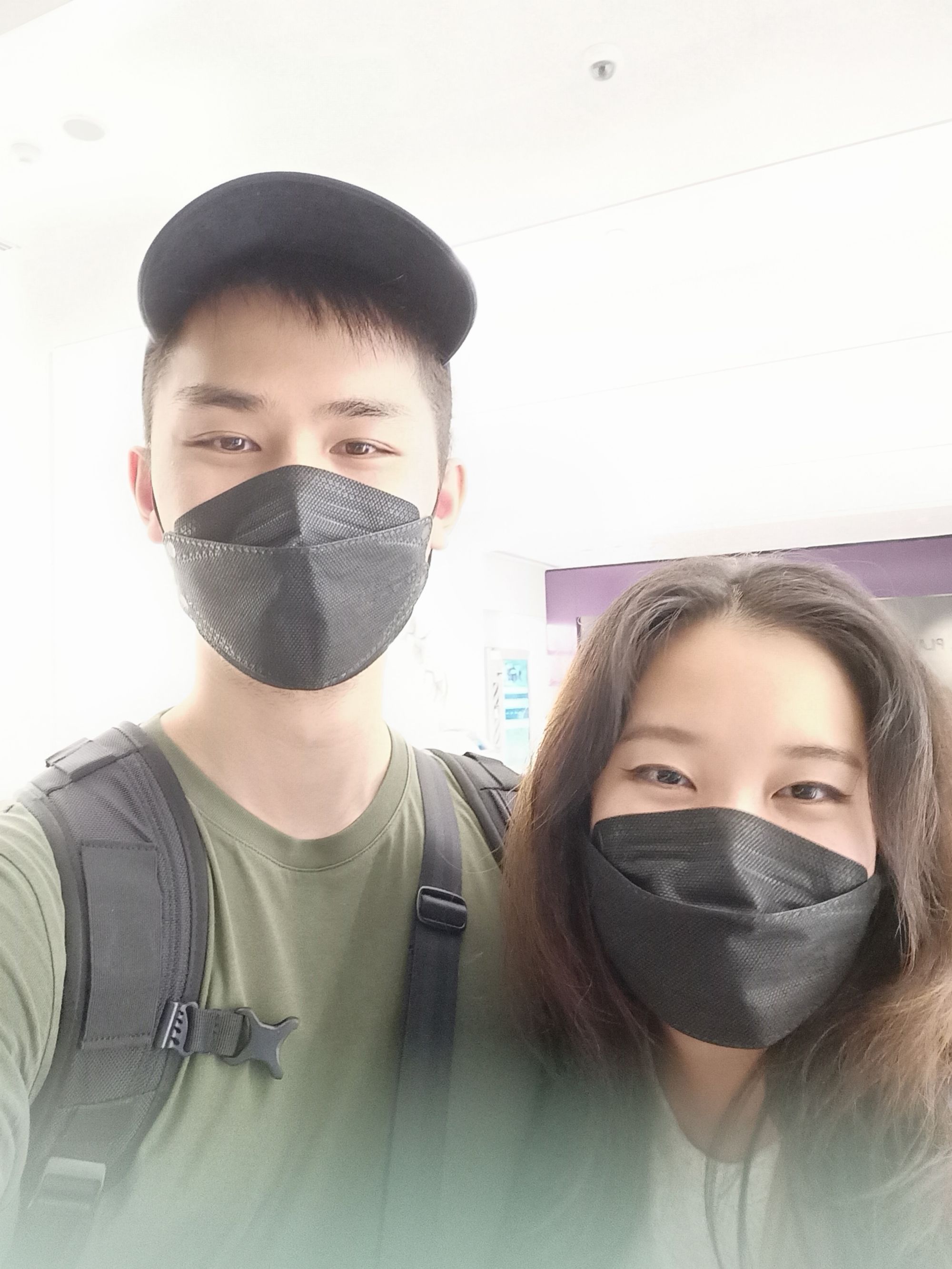 Selfie of an Asian couple wearing black face masks