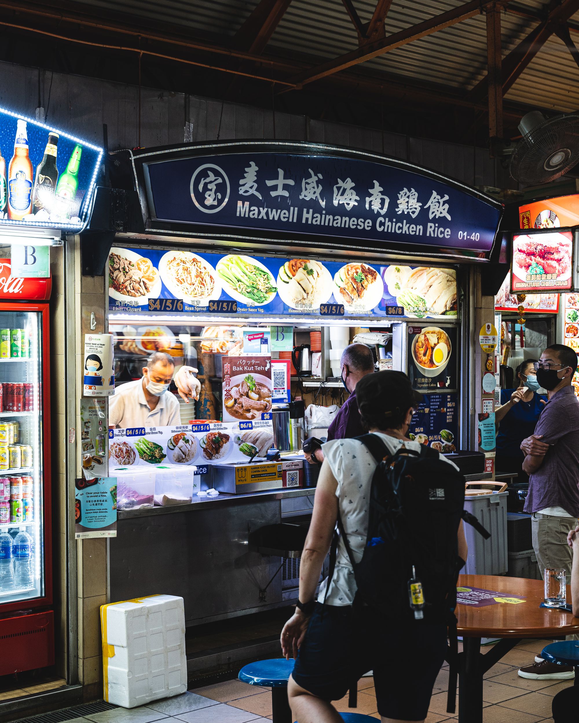 People standing in-front of a chicken rice stall