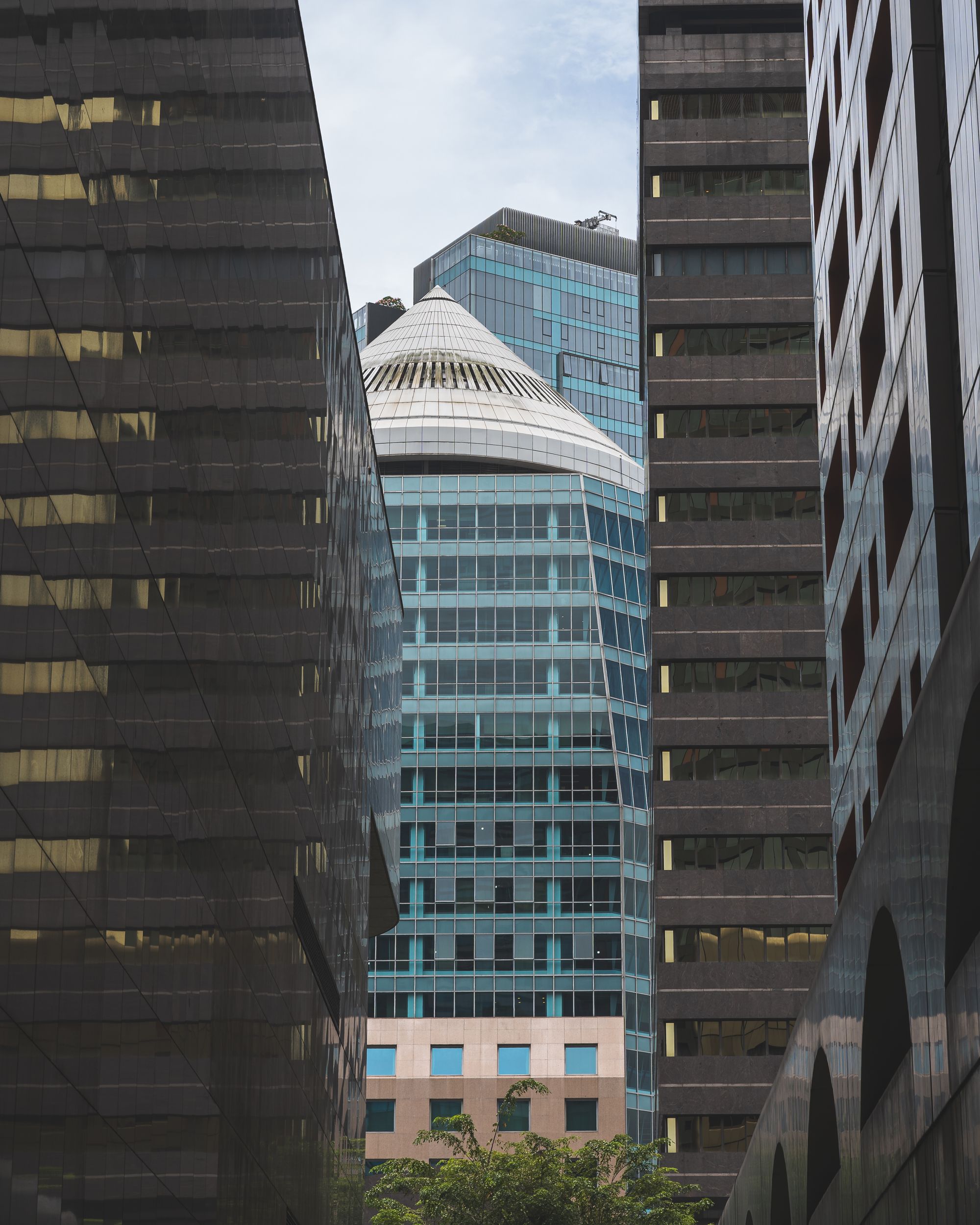 A tall pointy building being framed by other skyscrapers