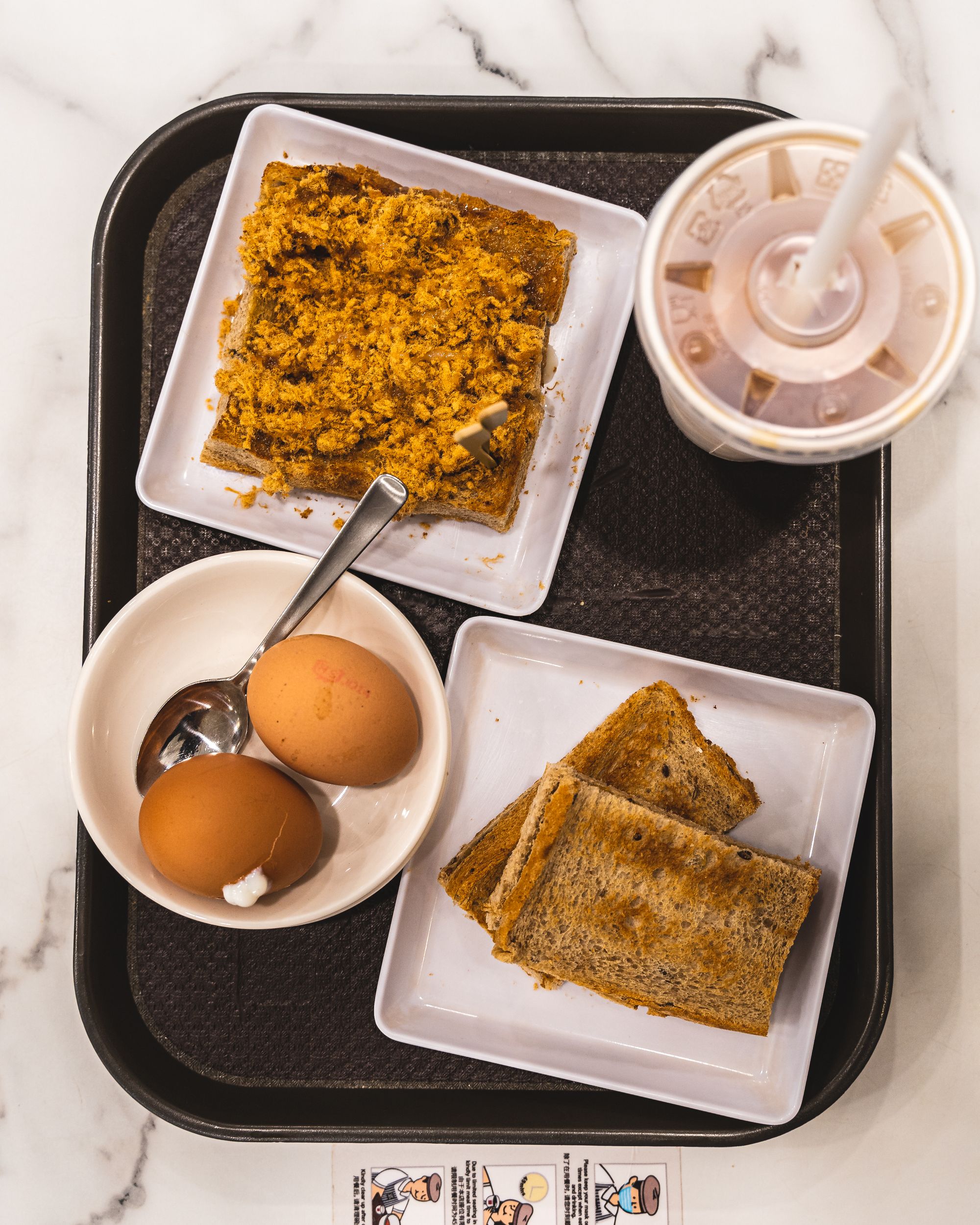 Top down shot of pork floss toast, kaya toast and soft boiled eggs