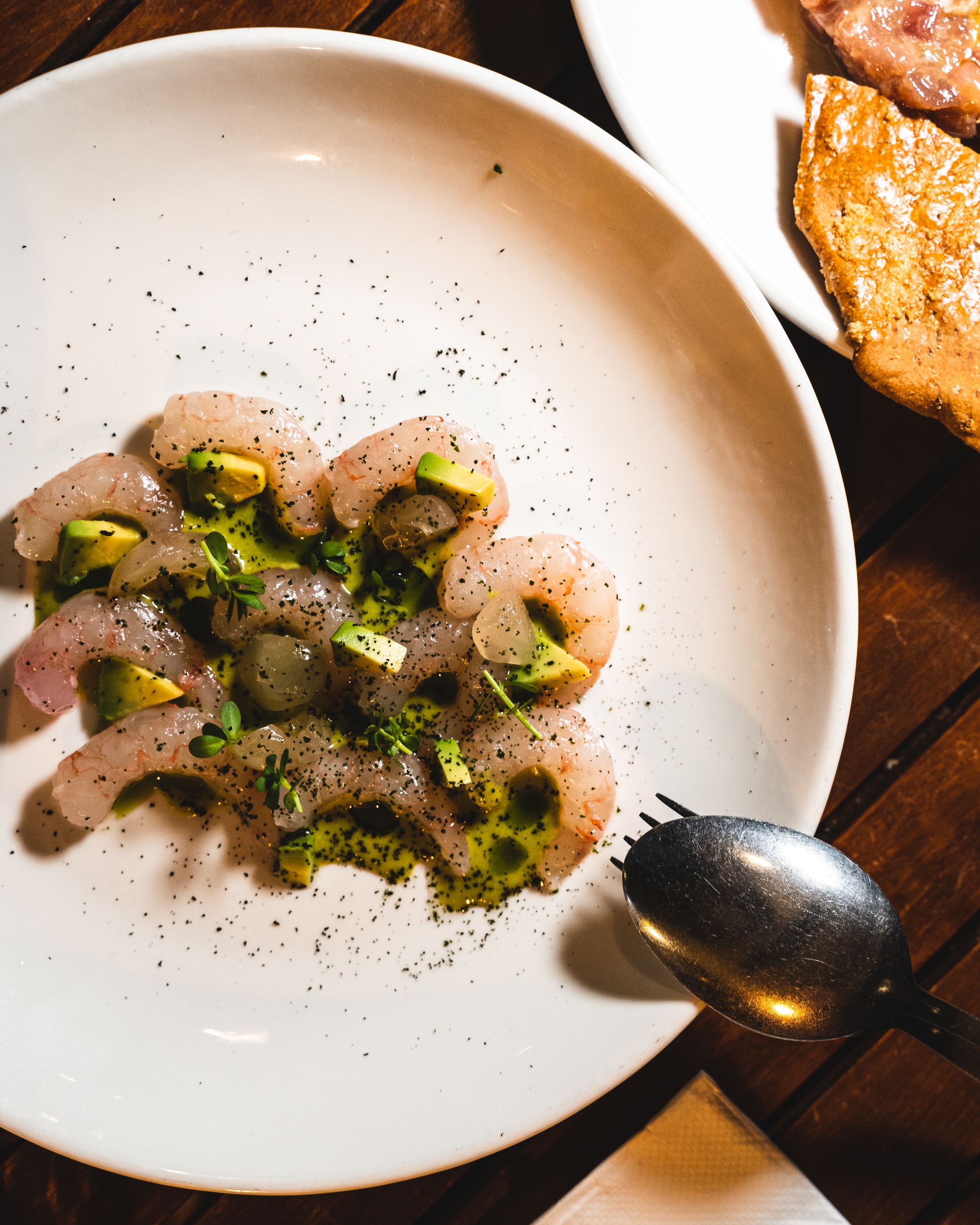 Birds eye shot of ama ebi dish with avocado, longan and seasoning