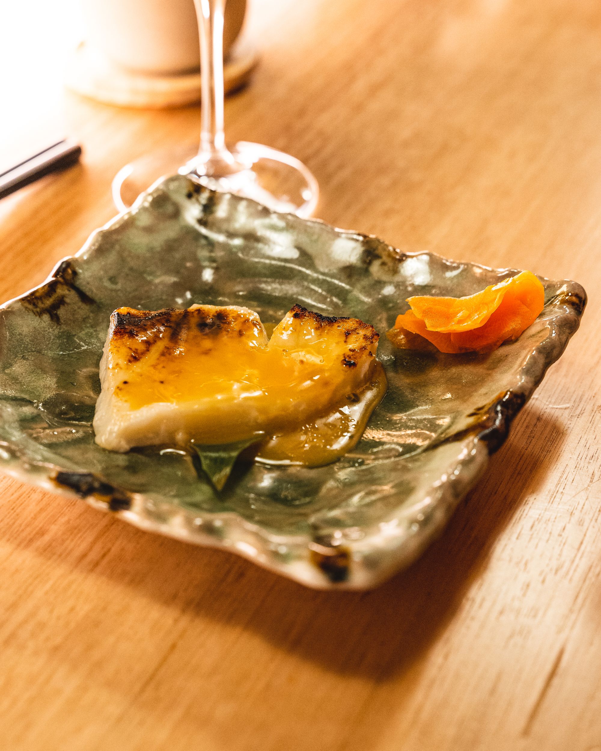 Close up of toothfish with miso sauce on a square plate