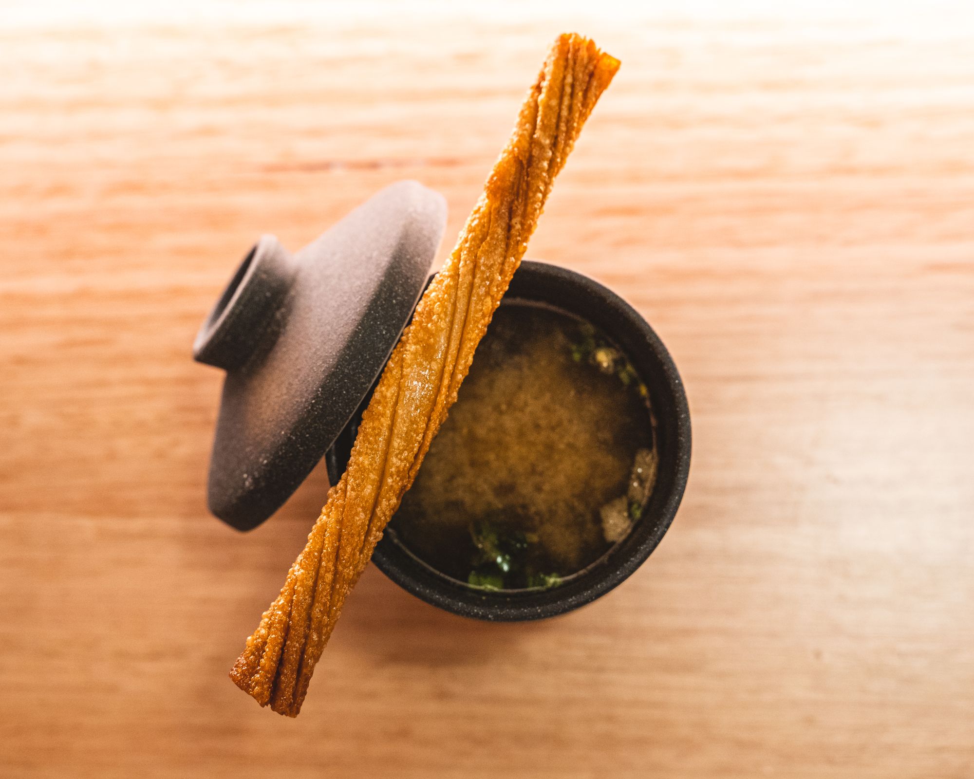 Close up of miso soul with a stick like object resting on-top