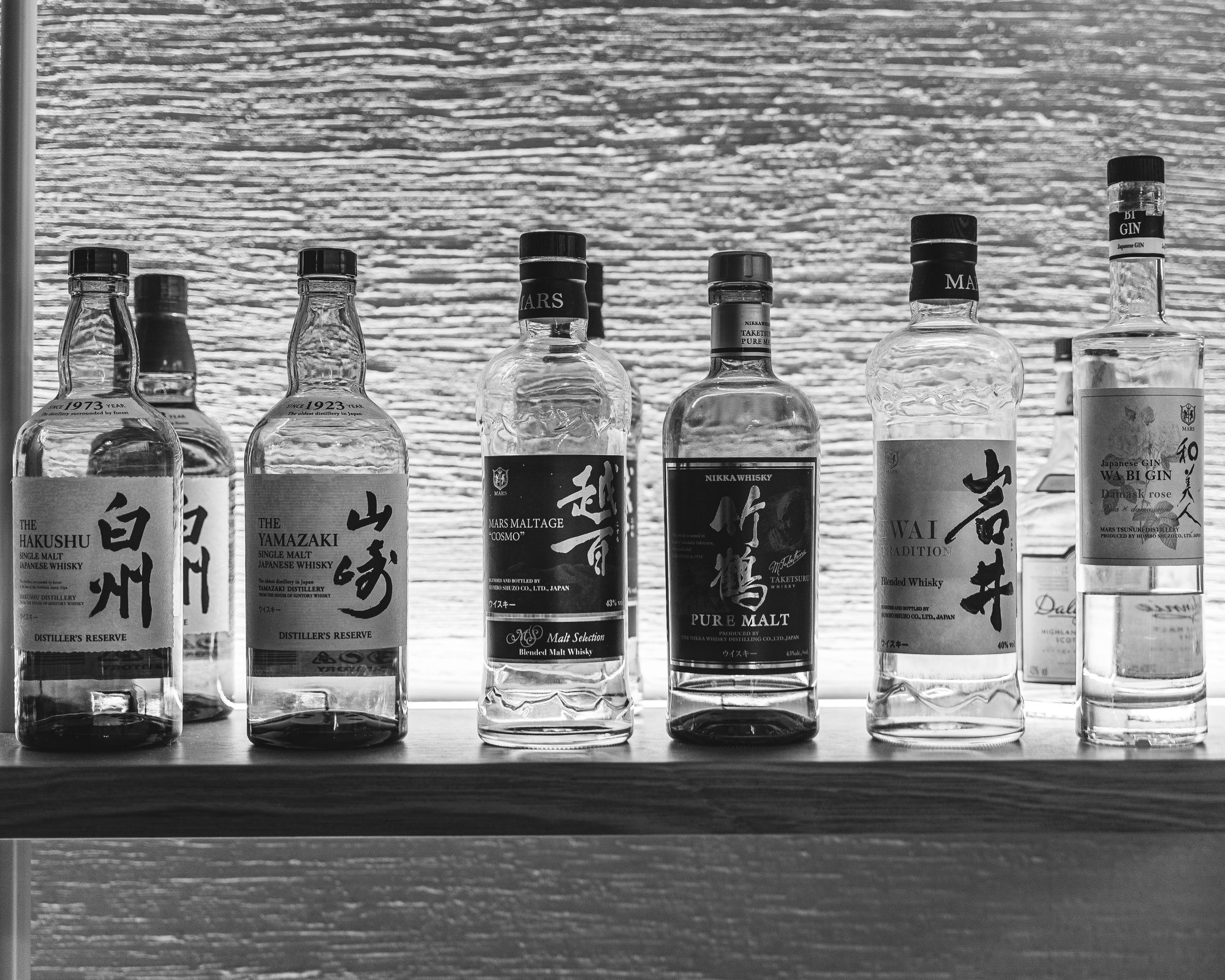 Black and white photo of Japanese whiskey on a shelf