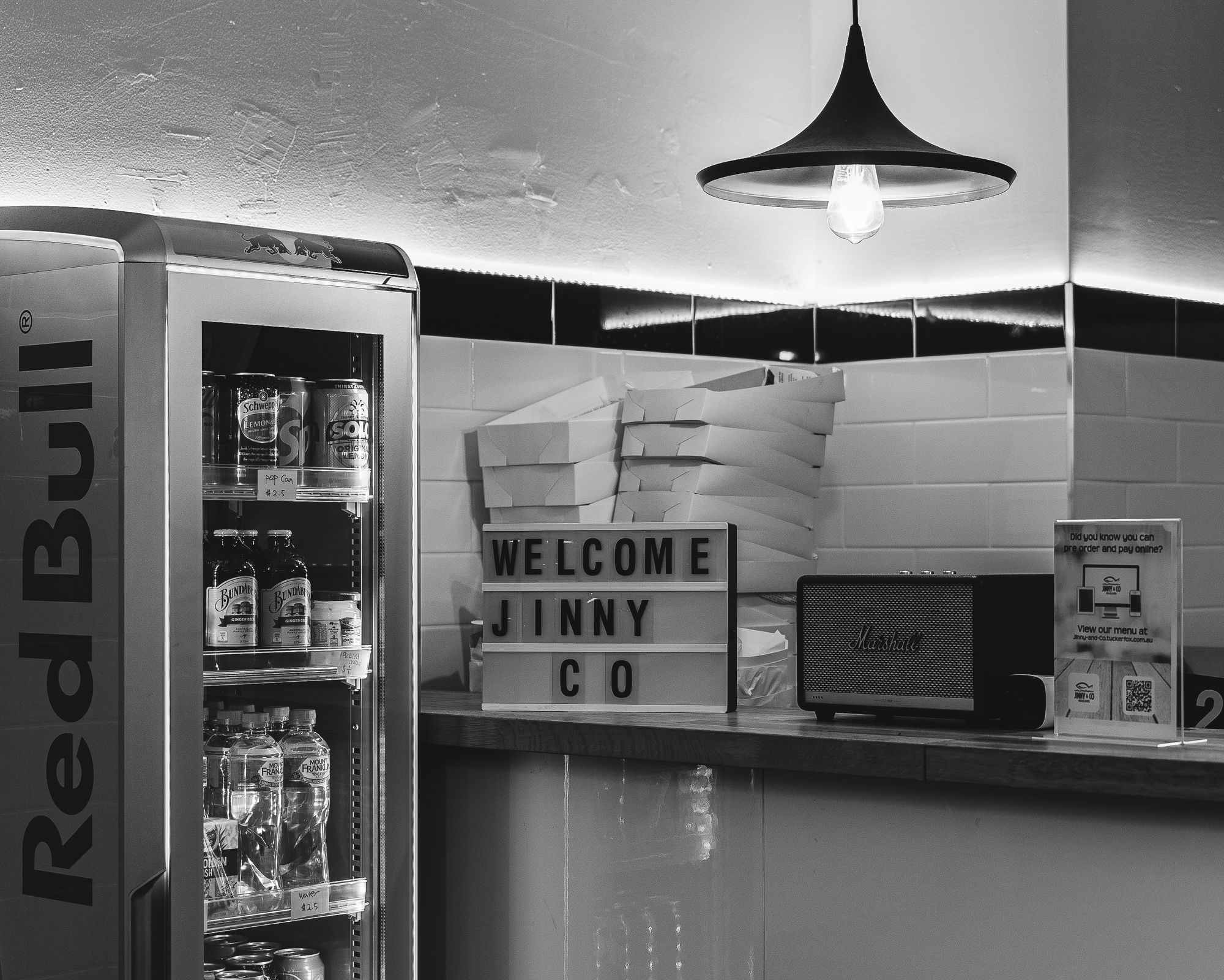 Black and white photo showing a sign that says "Welcome Jinny Co"