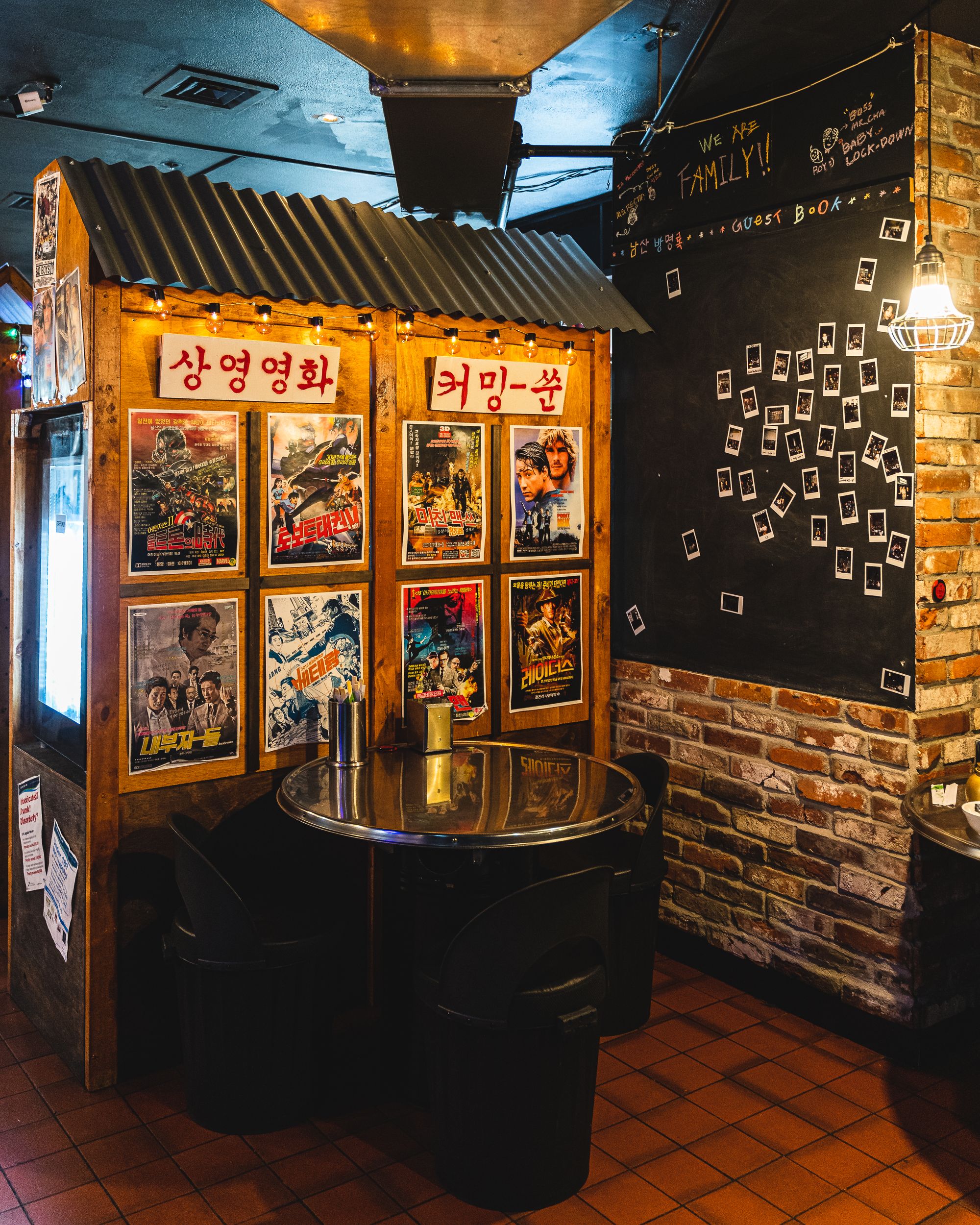 Interior of Namsan showing Korean film posters and a wall with polaroid photos of guests