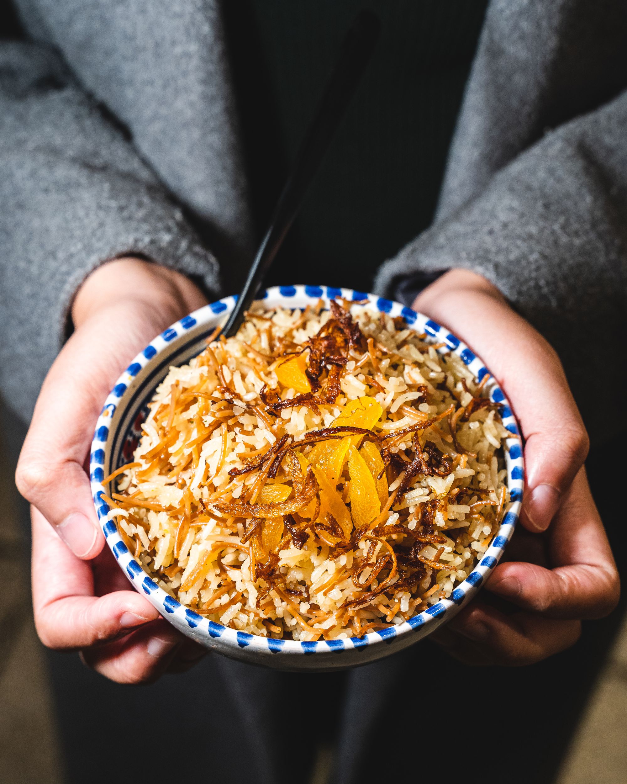 Close up of hands holding a bowl of basmati rice