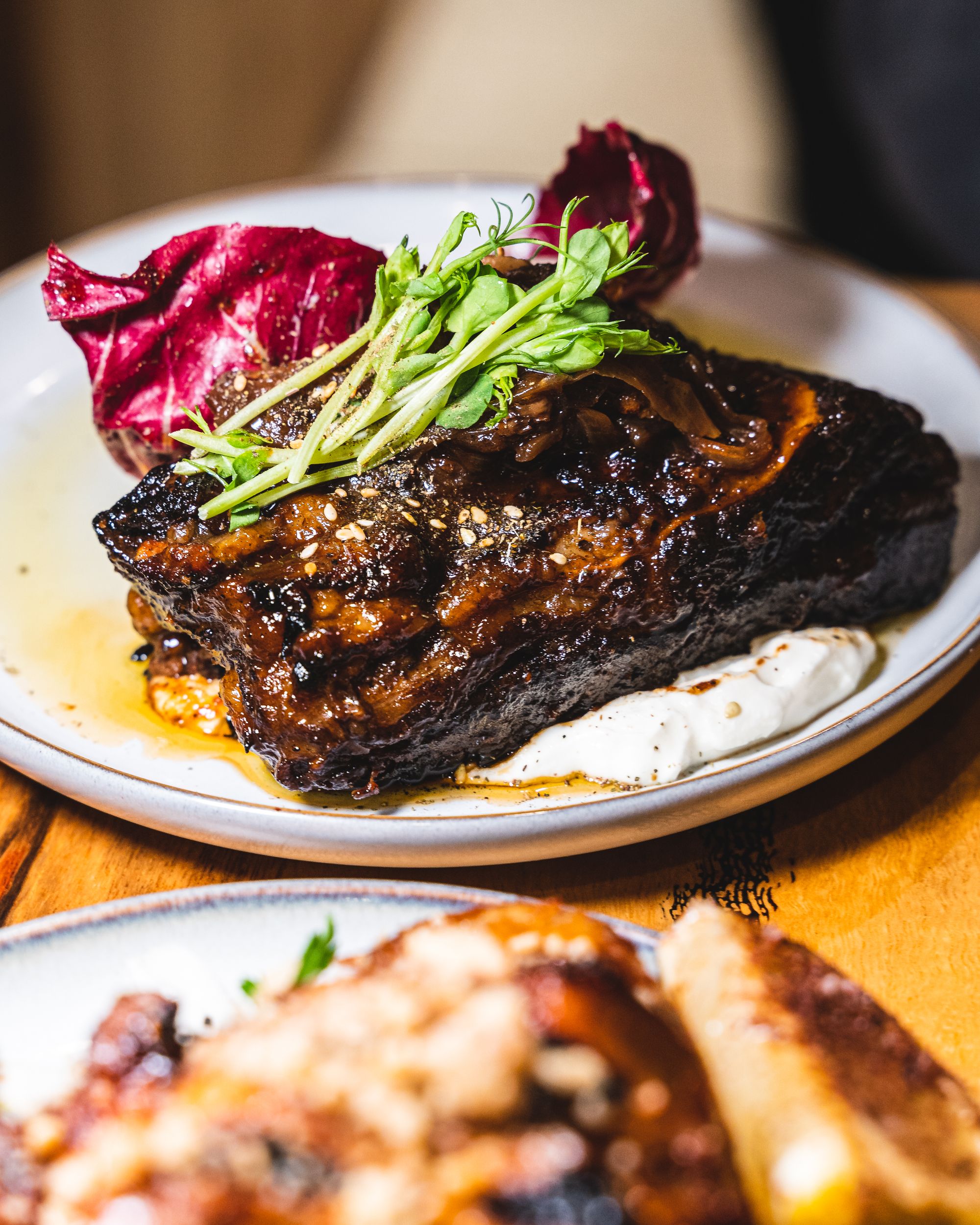 Close up of beef ribs served with microherbs on the top