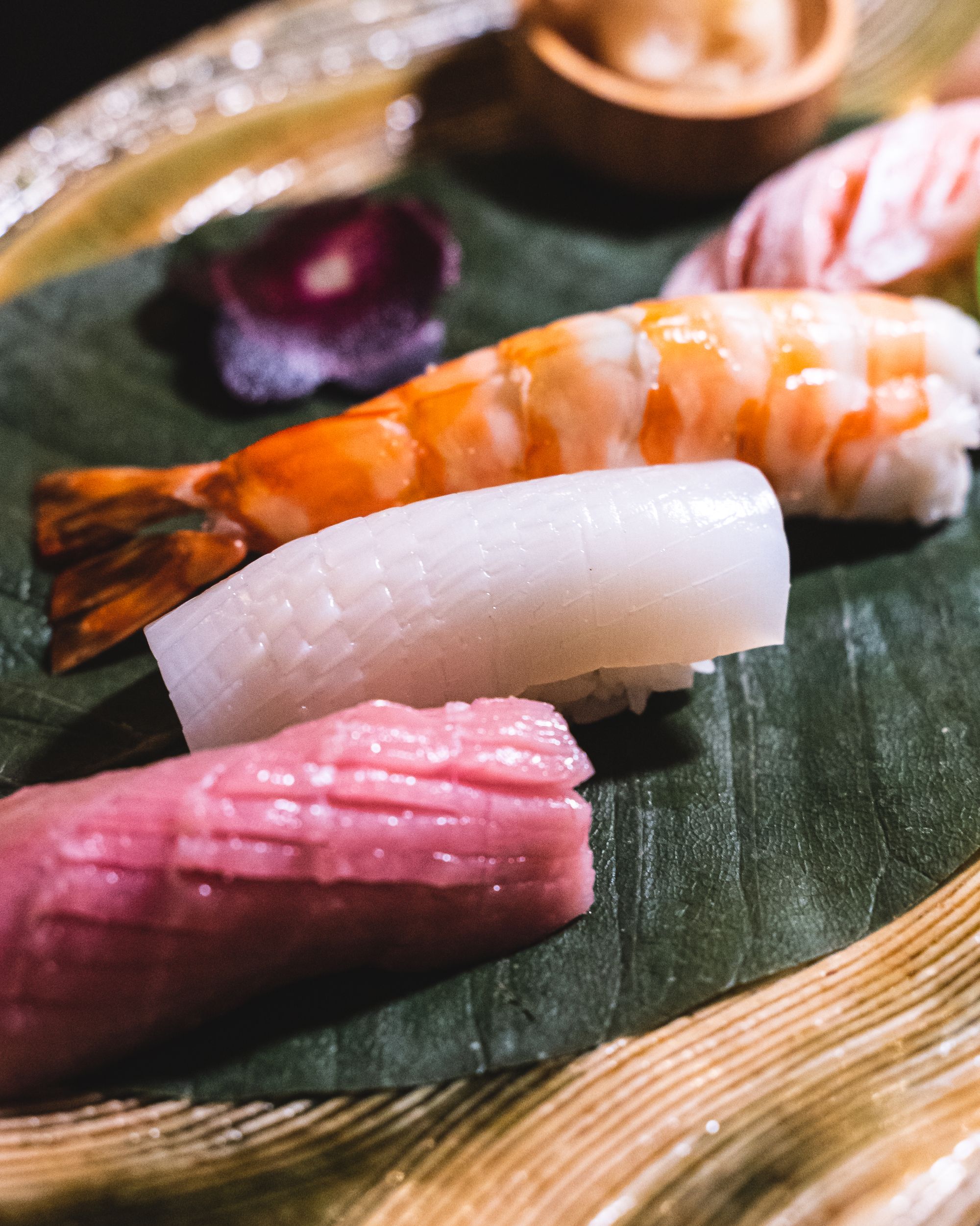 A close up of squid nigiri with delicate score marks in it