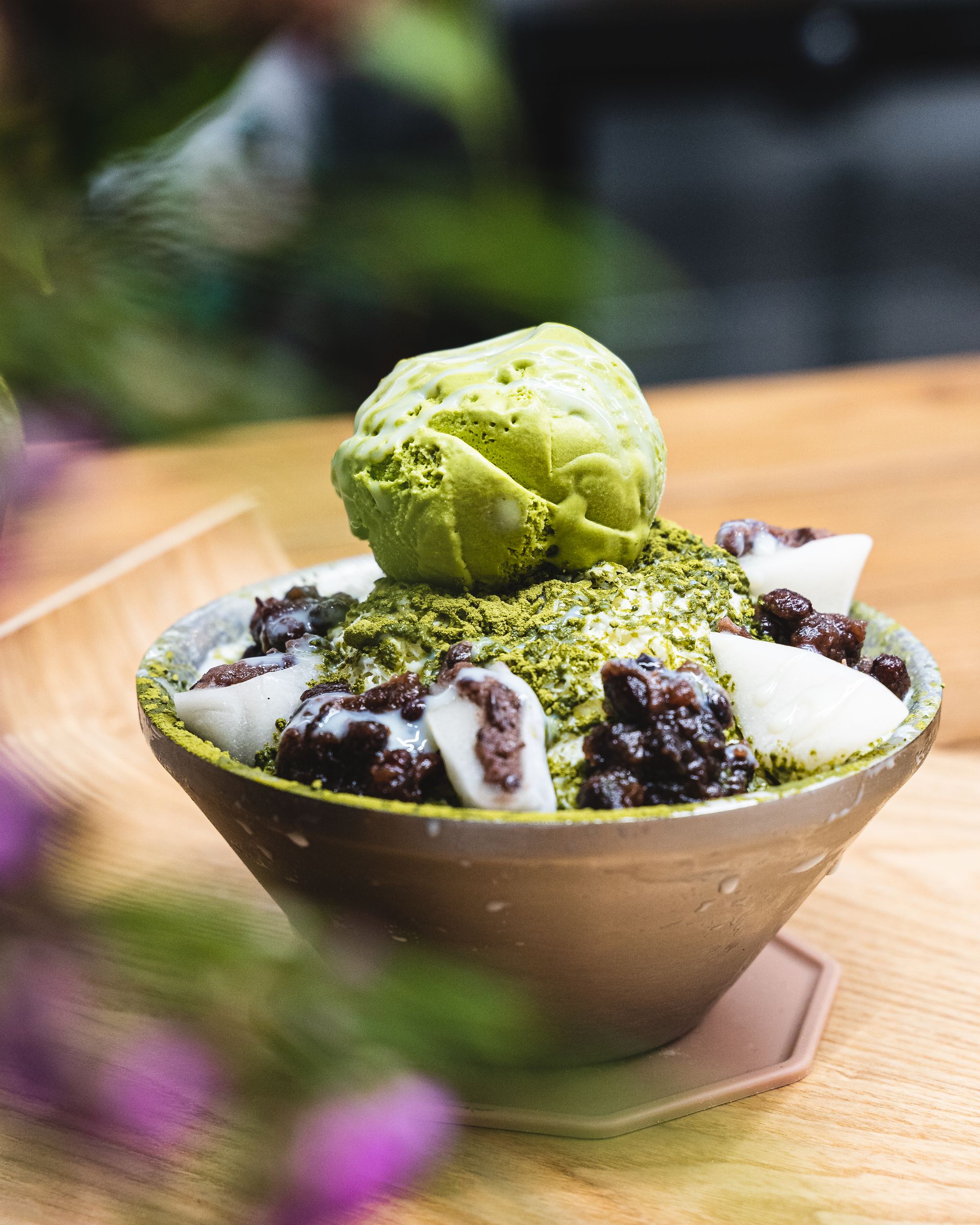 Close up of bingsu with a scoop of green tea ice-cream, red bean and mochi
