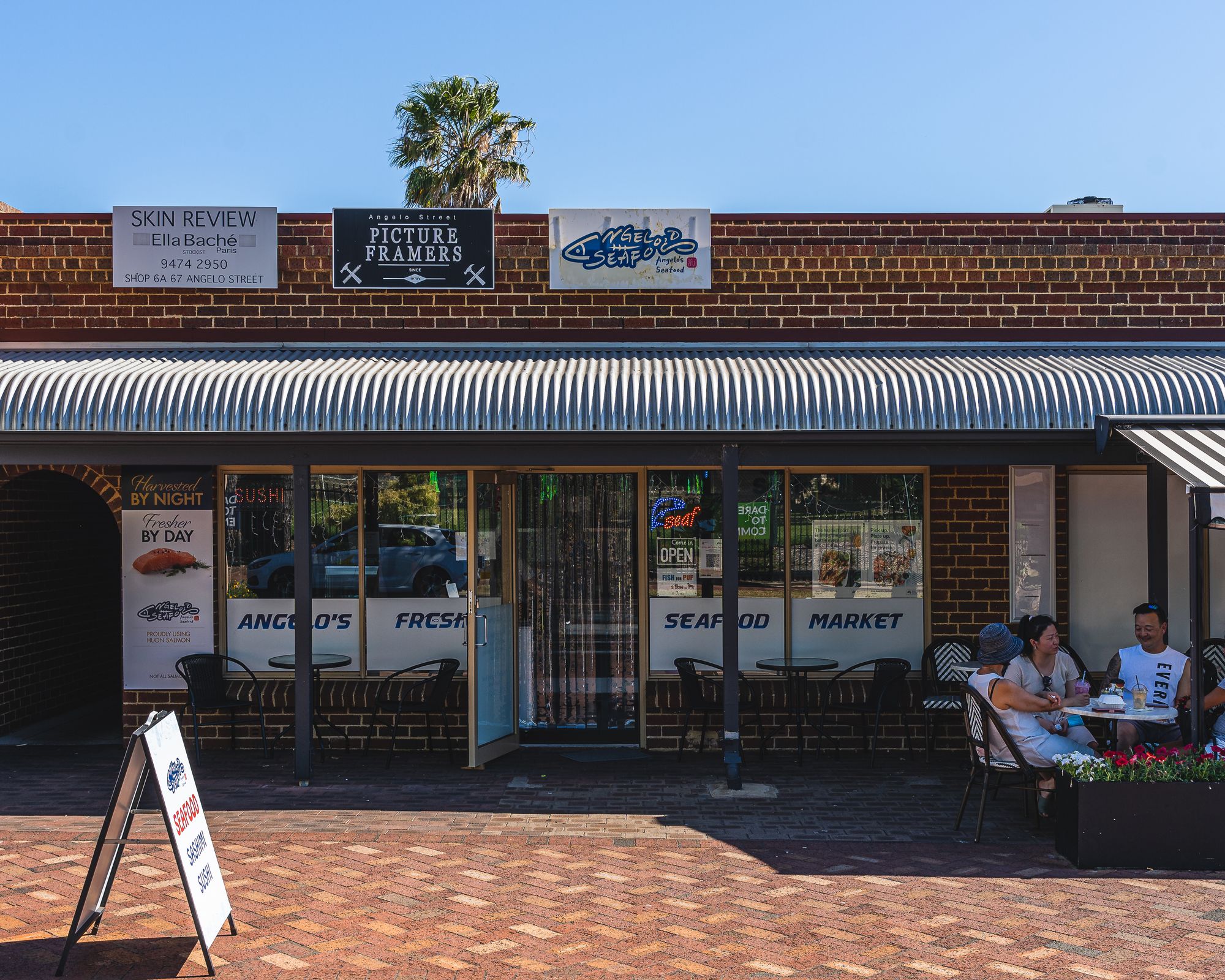 Exterior of Angelo's Seafood showing people dining outsides