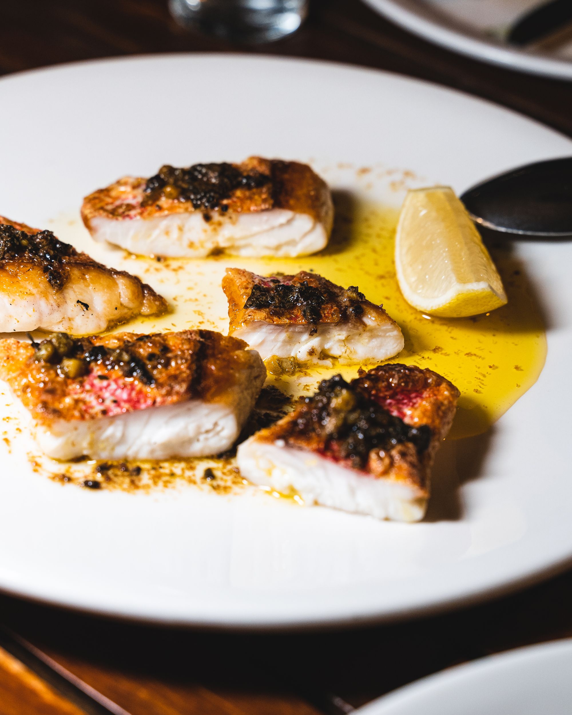 Close up of fish fillet pieces with a butter sauce and lemon