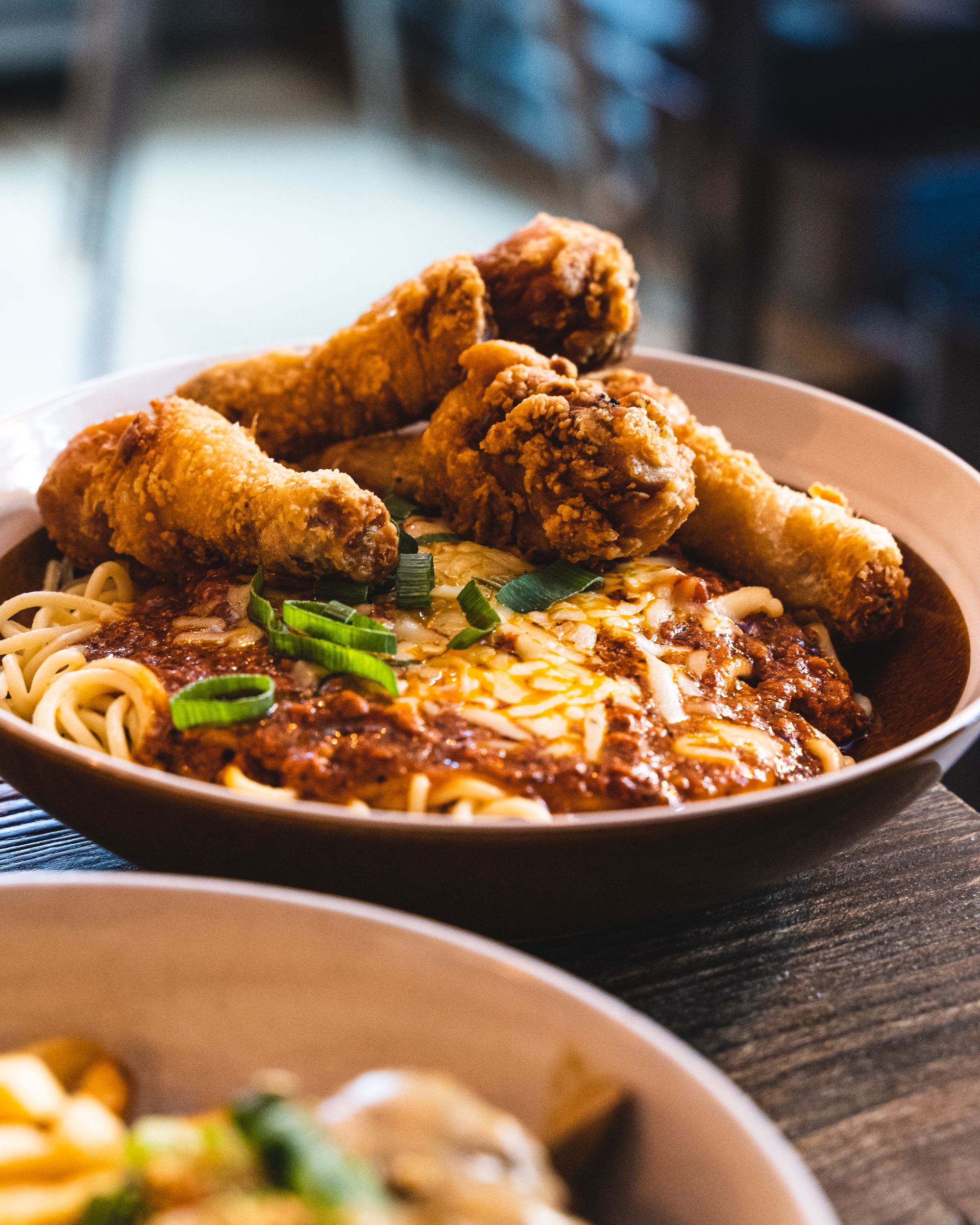 Close up of spaghetti with four pieces of fried chicken on-top