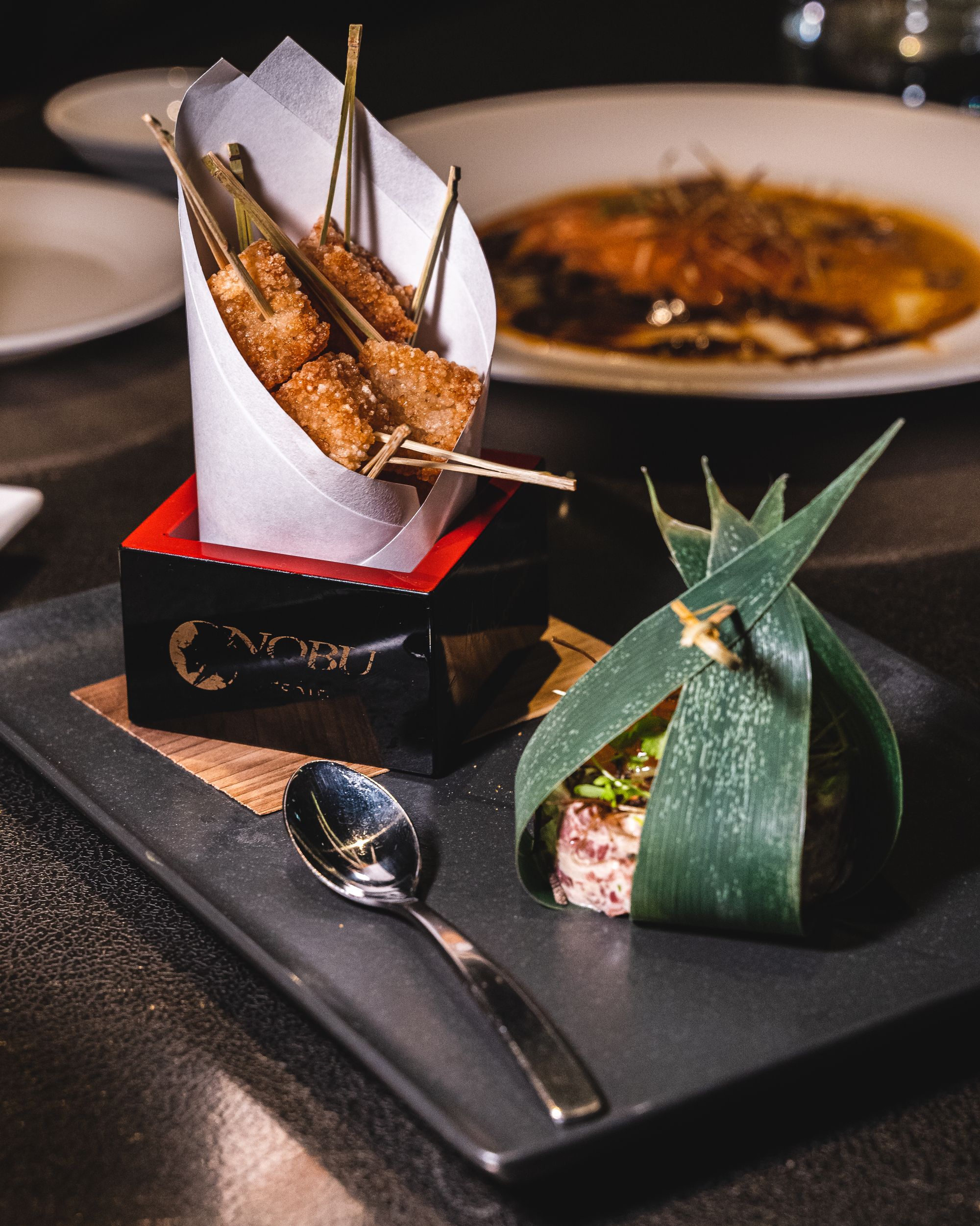 Plate with tried rice cubes, a demi spoon and beef tartare