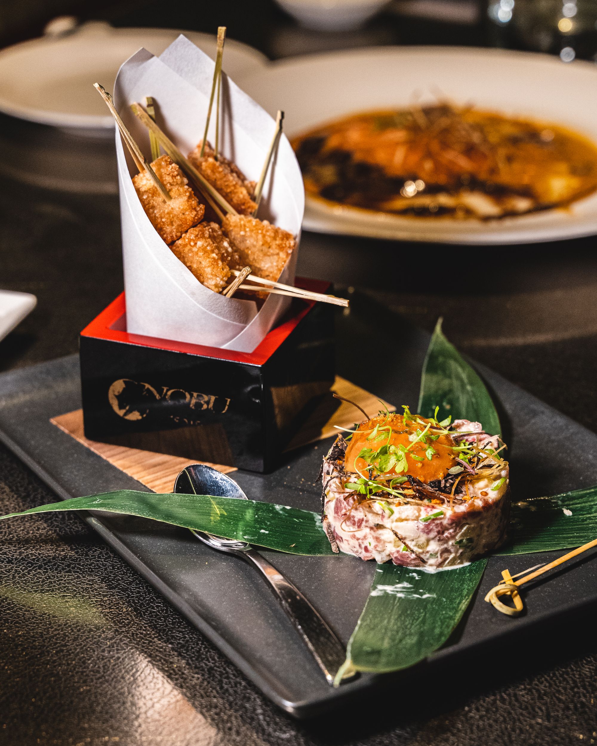 Plate with tried rice cubes, a demi spoon and beef tartare