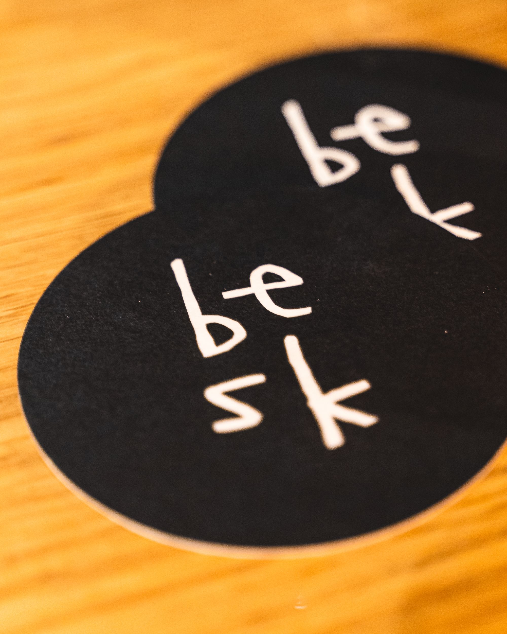 Two drink coasters with "Besk" branding on it