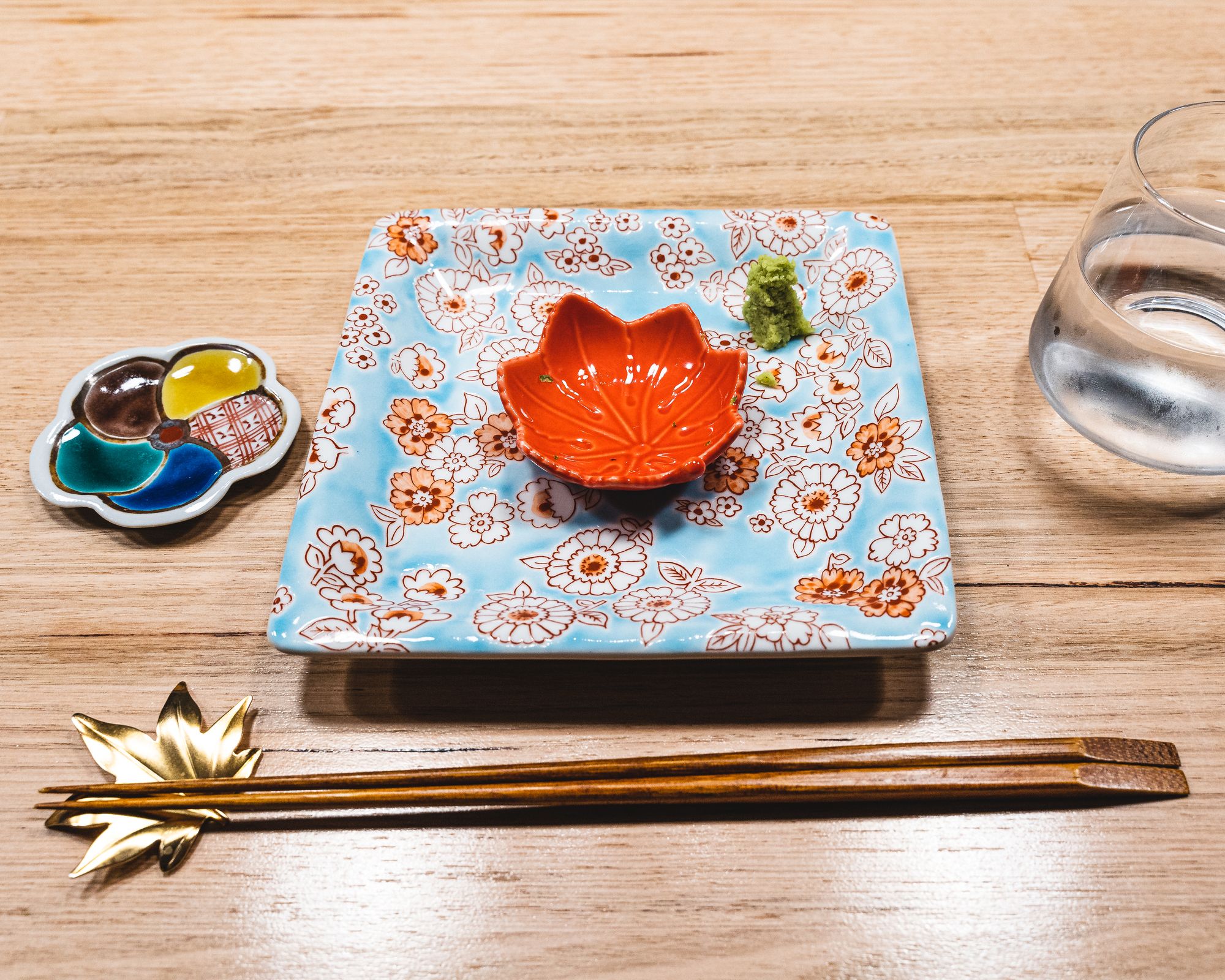 Tablesetting - Japanese plates, a gold maple leaf shaped chopstick rest with a pair of chopsticks on top
