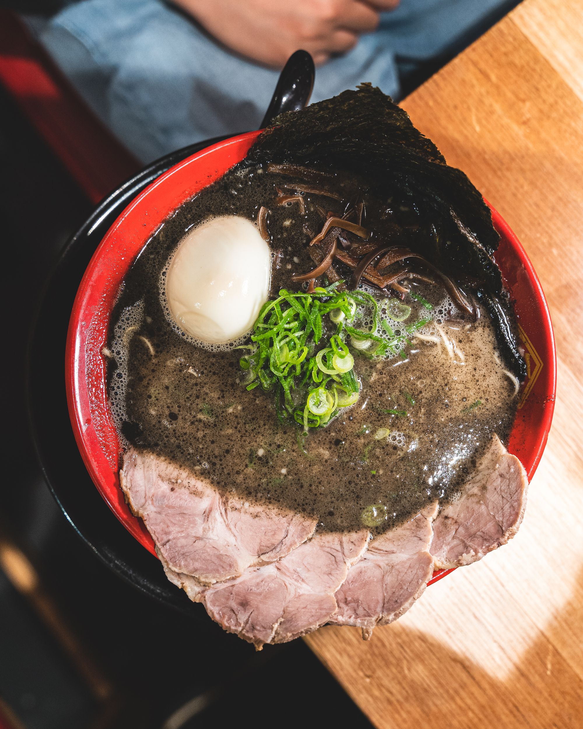 Top down shot of ramen with pork, egg and spring onion and seaweed showing