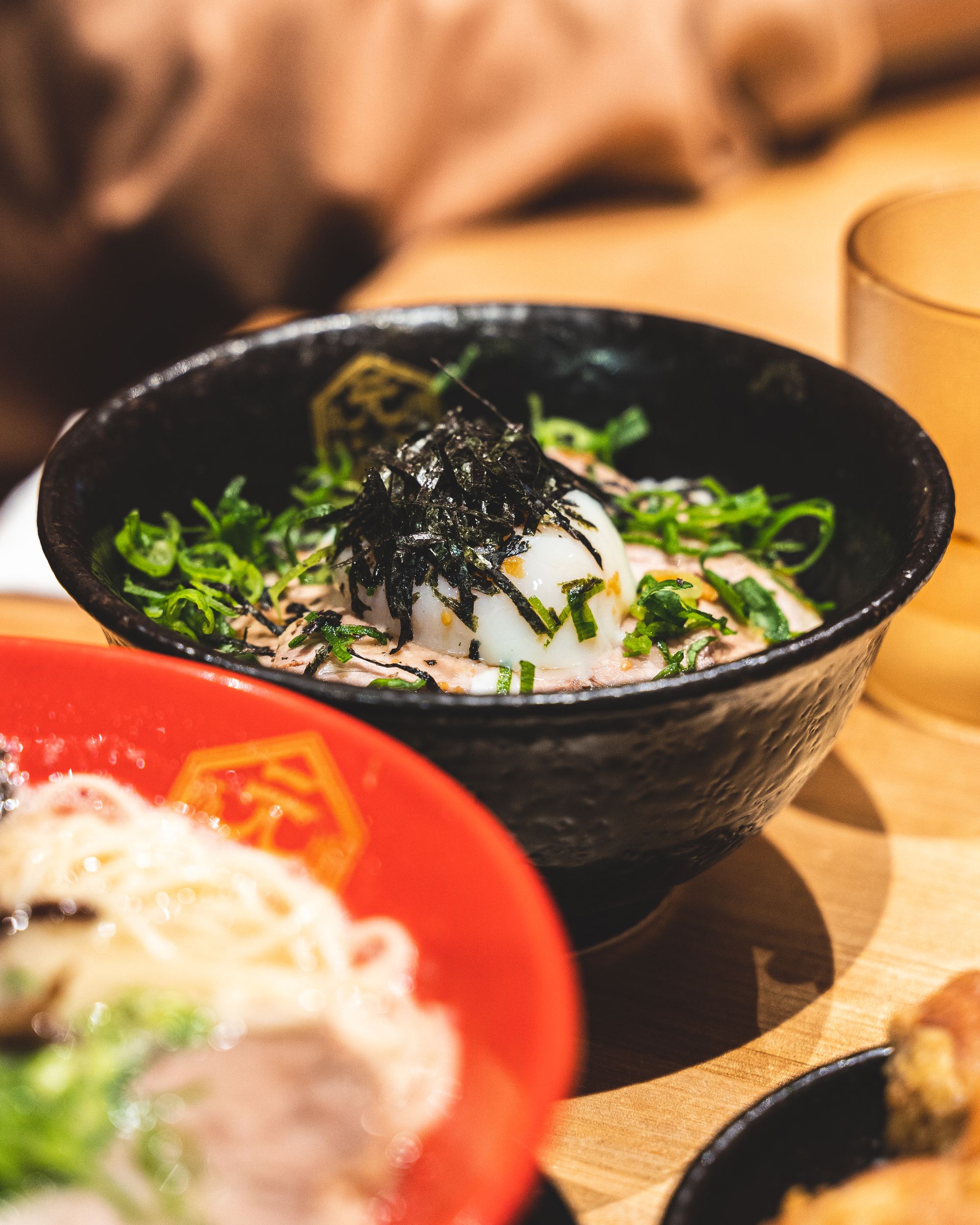 Close up of rice bowl with poached egg with seaweed and spring onion garnish