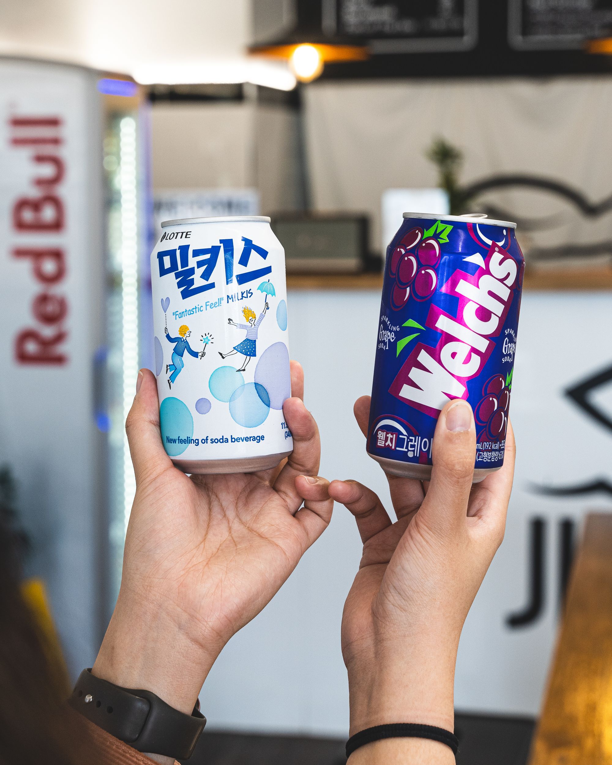 Close up of hands holding two cans of soft drink