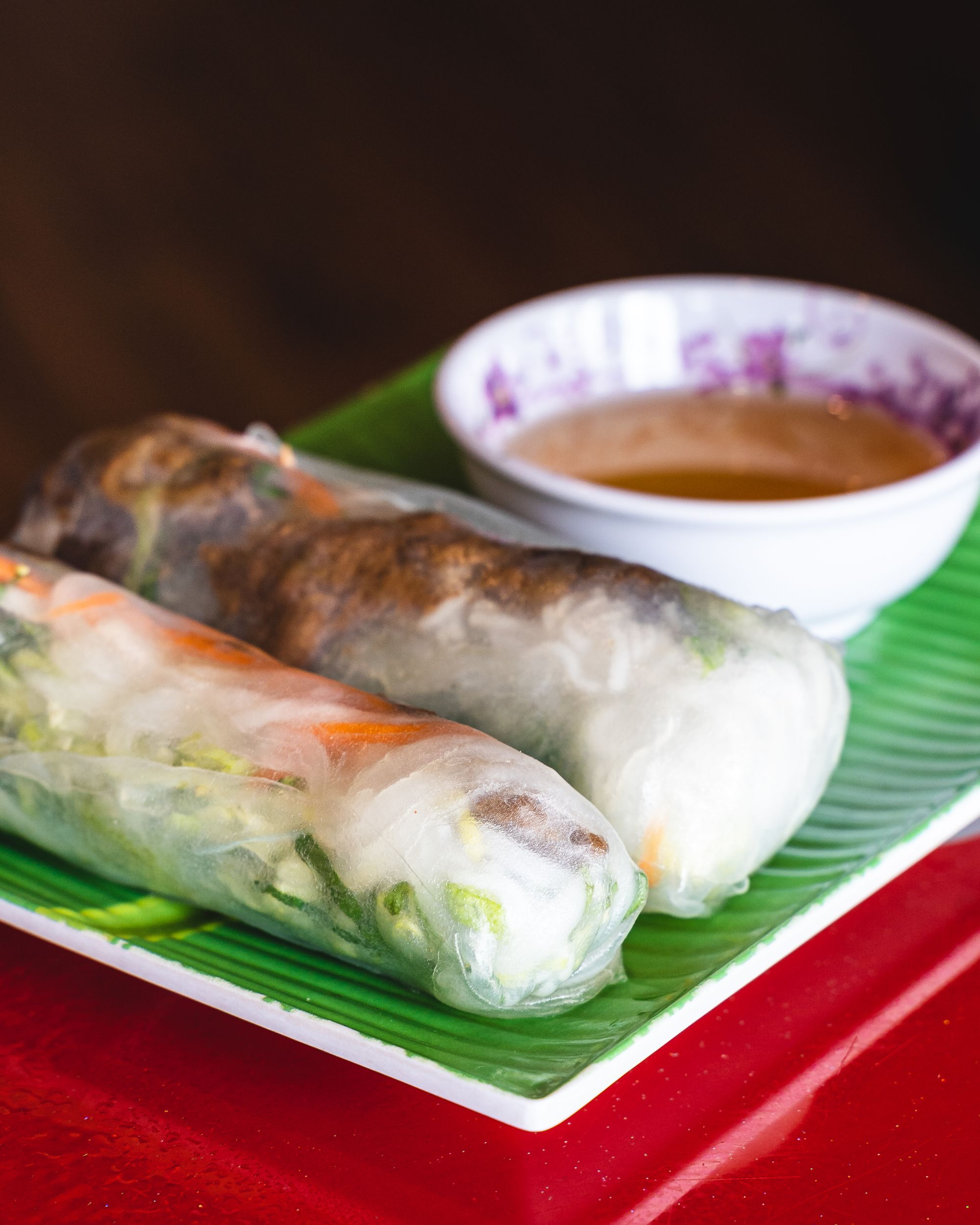 Close up of rice paper rolls with a condiment of fish sauce