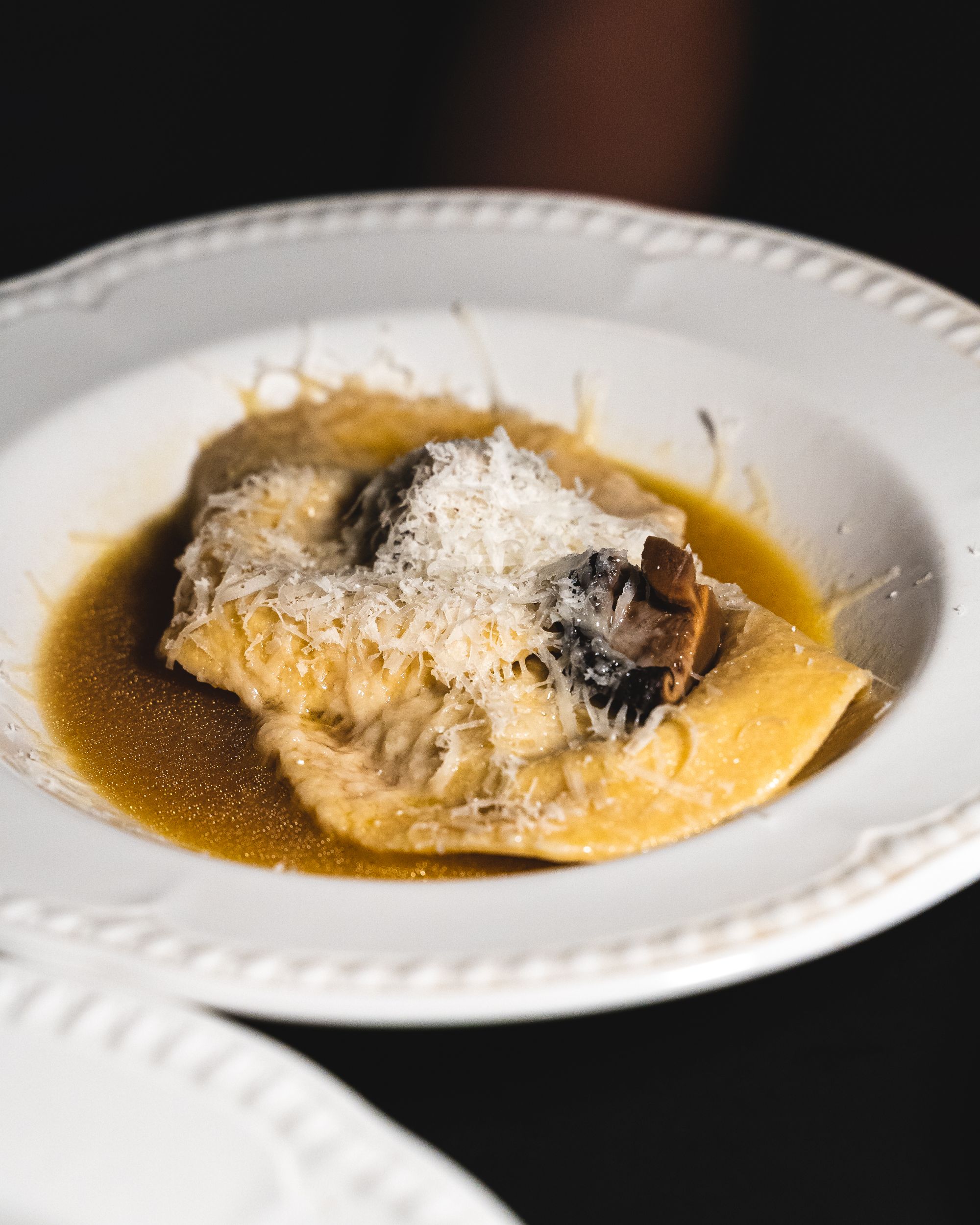 Close up of ravioloni with shaved cheese