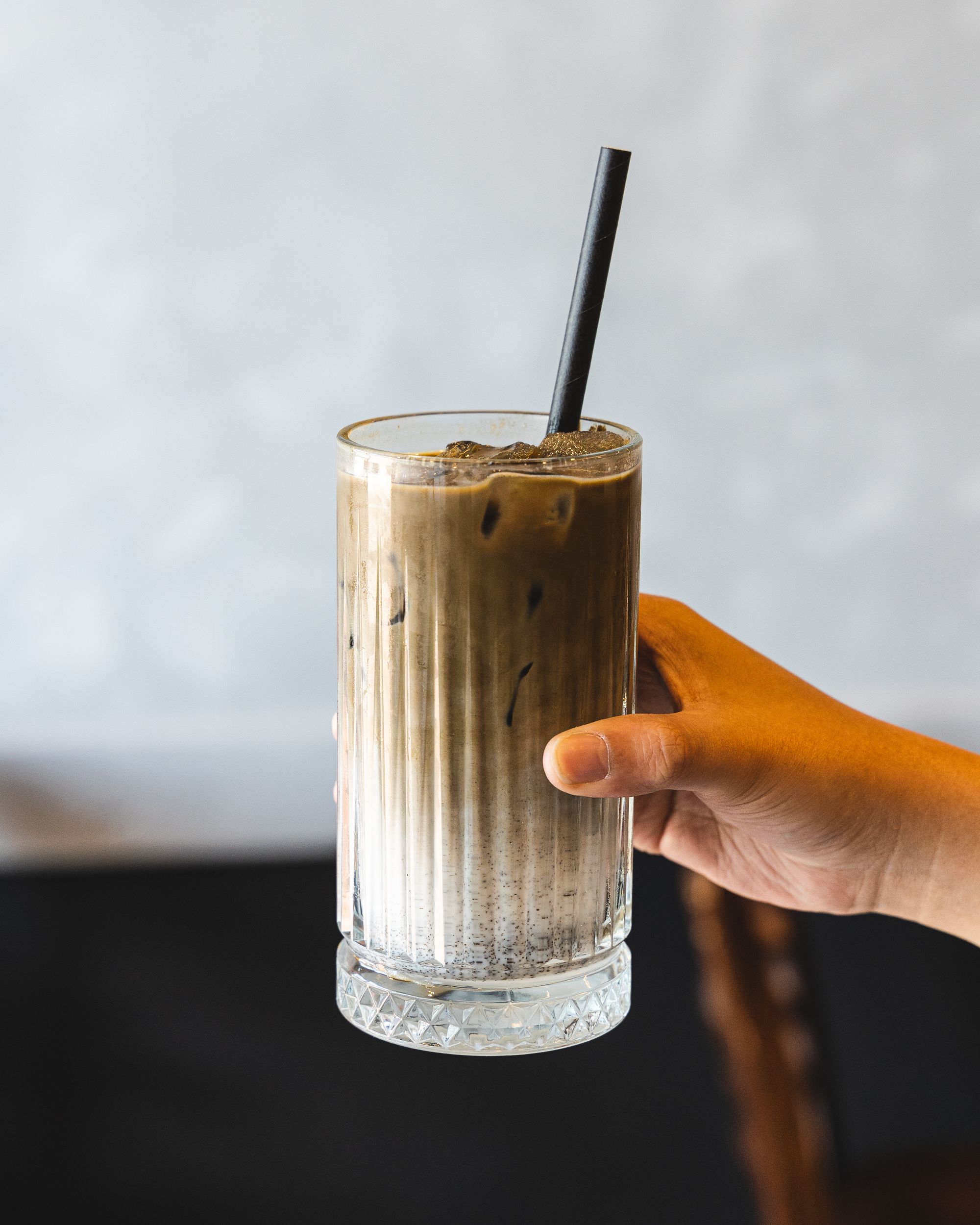 Hand holding an iced matcha latte