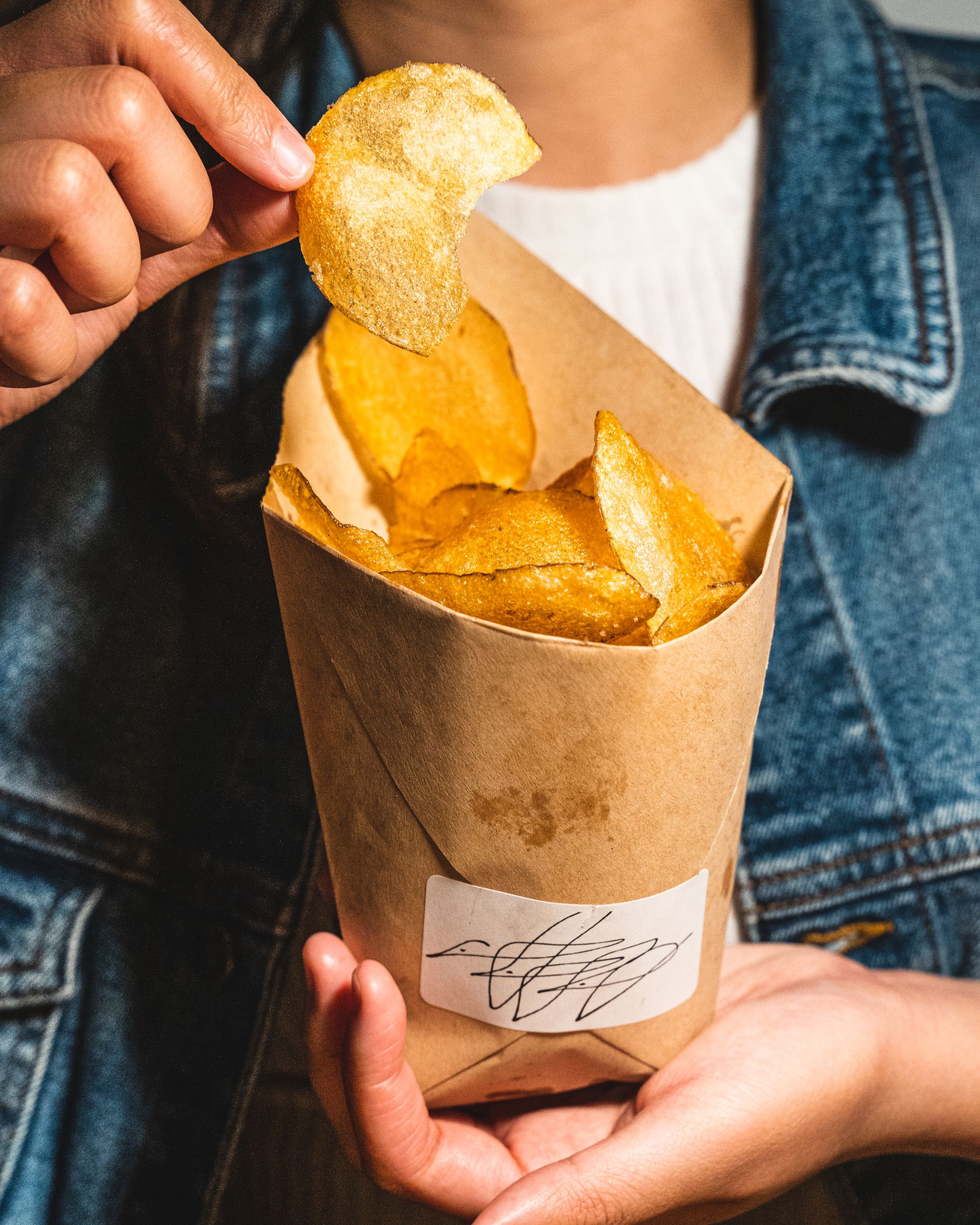 Hand holding a bag of potato crisps