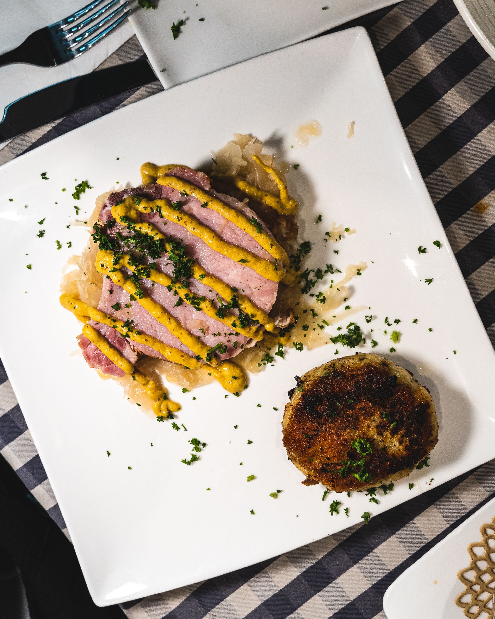 Top down shot of steamed pork chop with mustard and potato