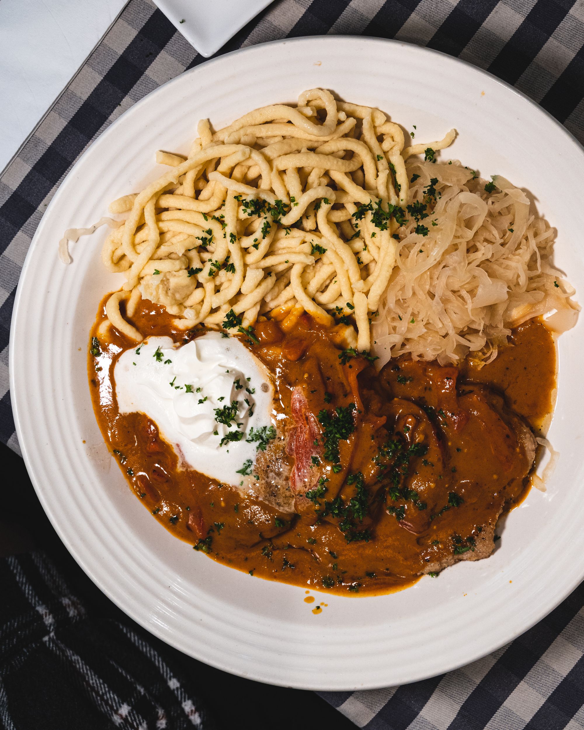 Top down shot of schnitzel and tomato sauce and spatzle