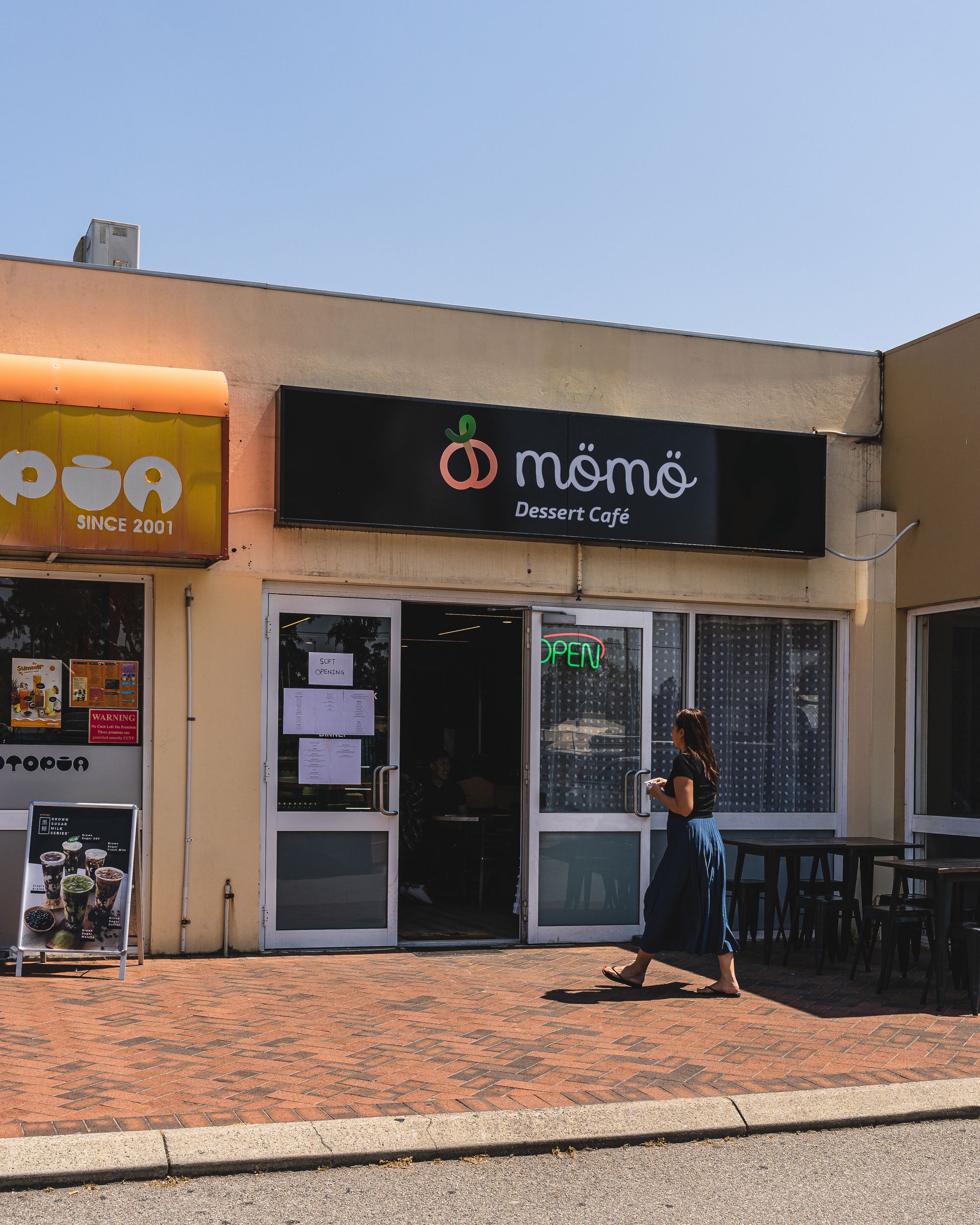 Exterior of Momo Dessert Cafe with customer walking in