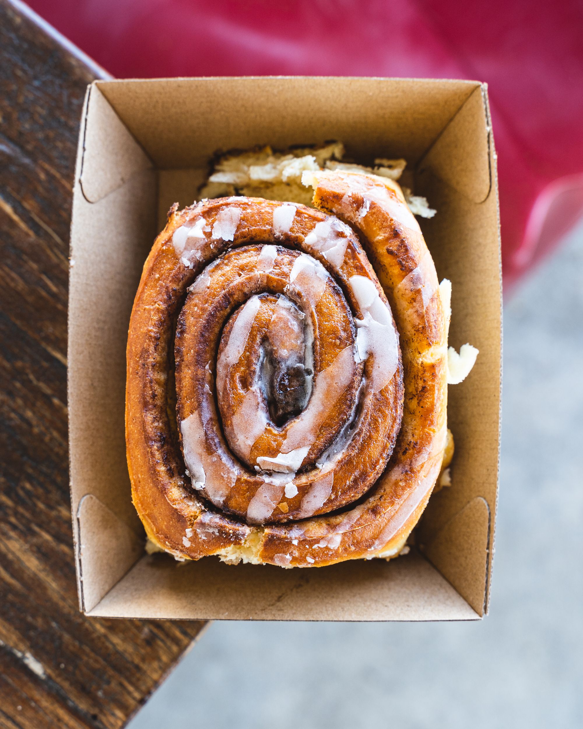 Top down shot of a cinnamon scroll with icing sugar