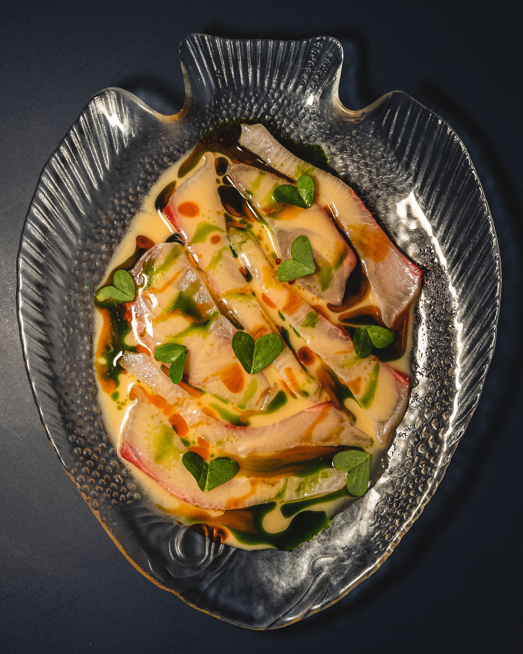 Top down shot of kingfish ceviche served in a fish plate