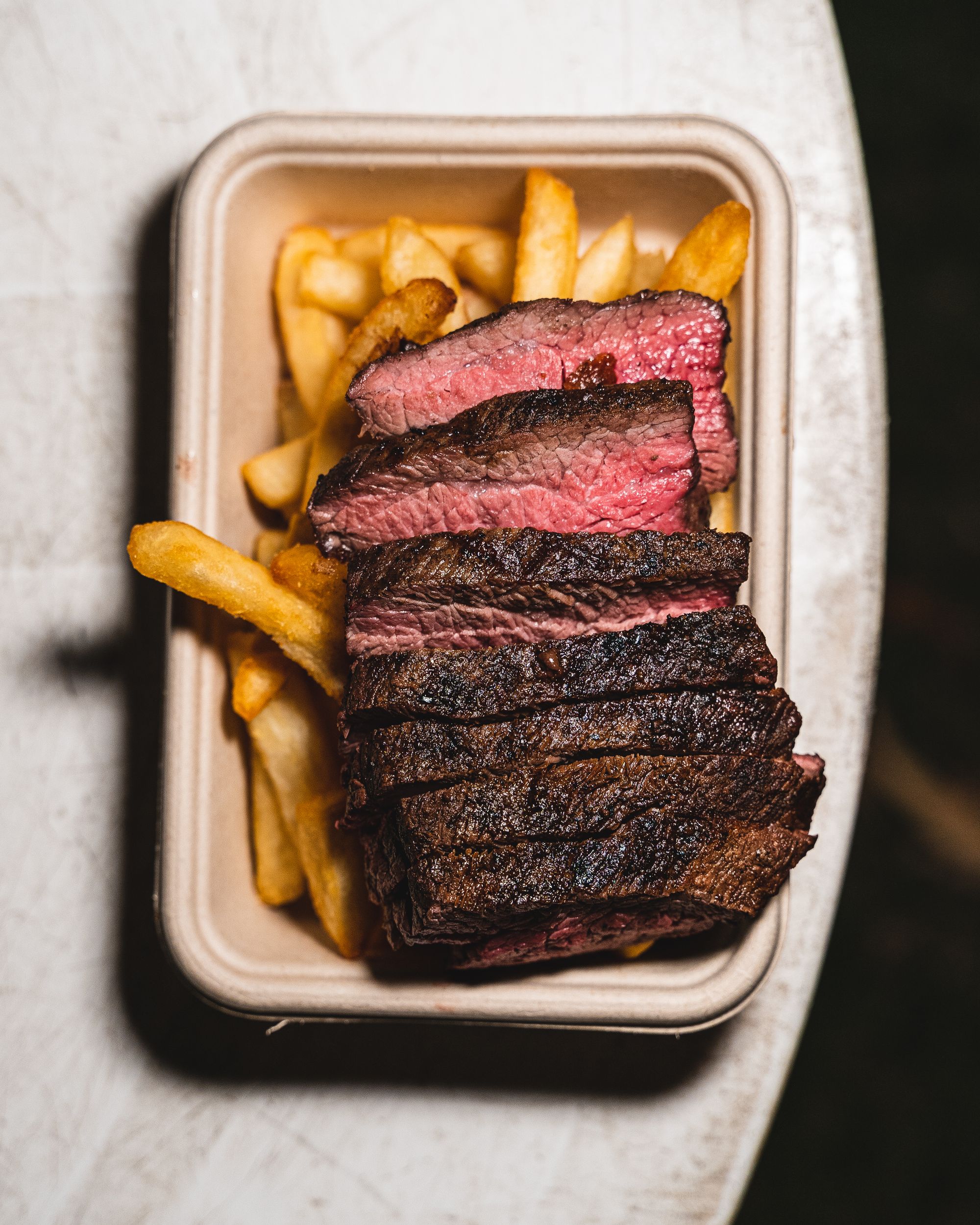 Top down shot of steak on-top of fries