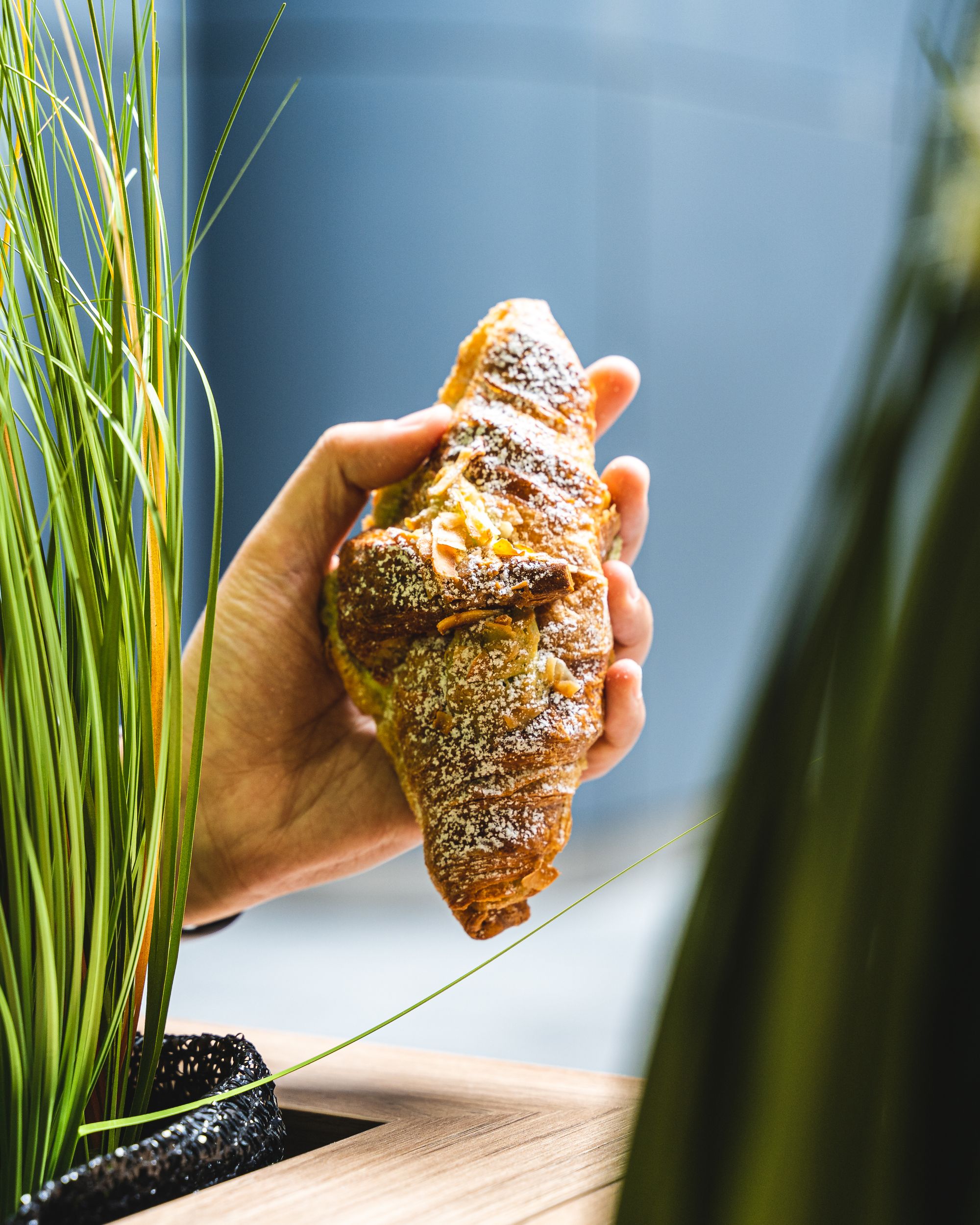 Hand holding almond croissant