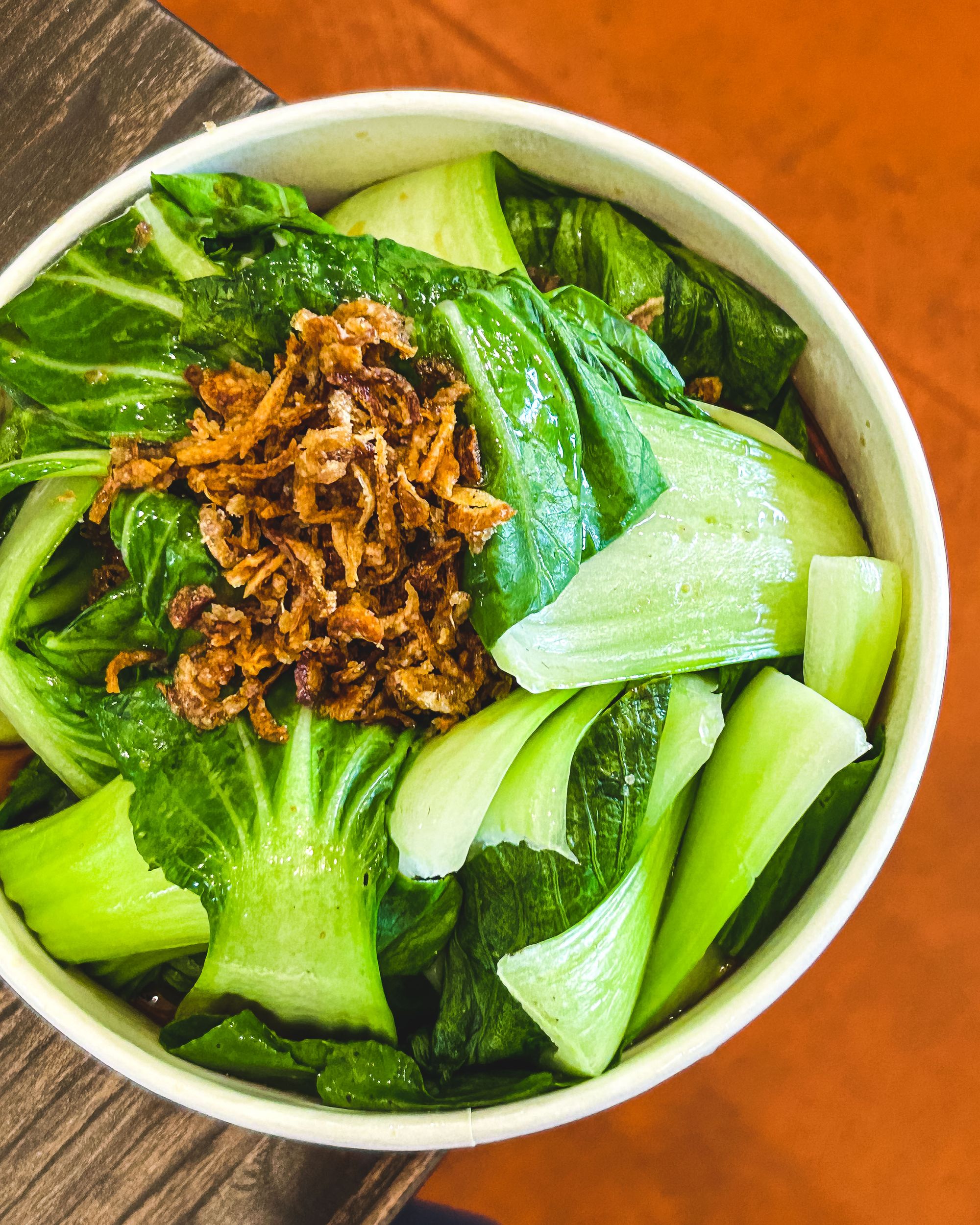 Overhead shot of bok choy with shallots on top